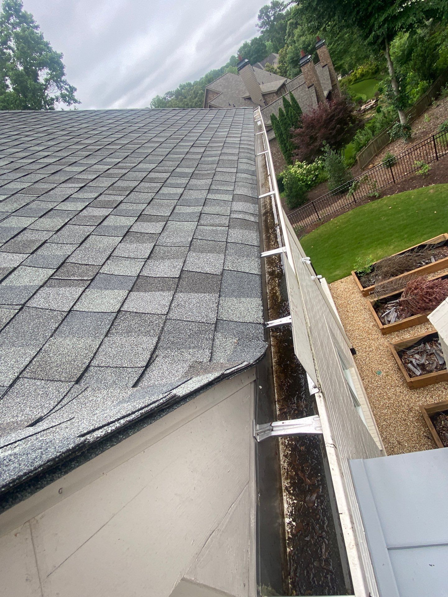 Technician checking hanger spacing along a gutter run