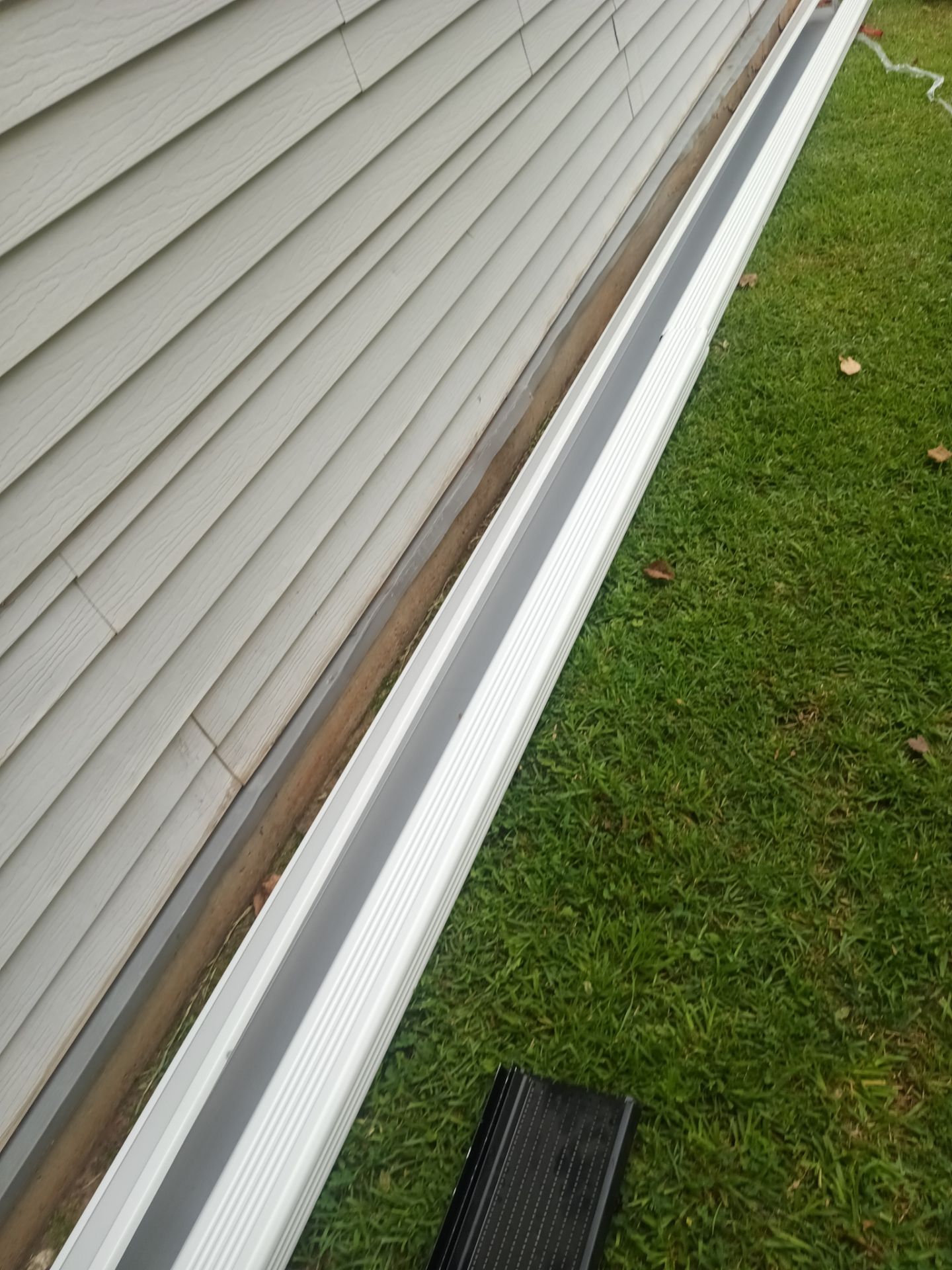 Single sagging bracket near a downspout outlet