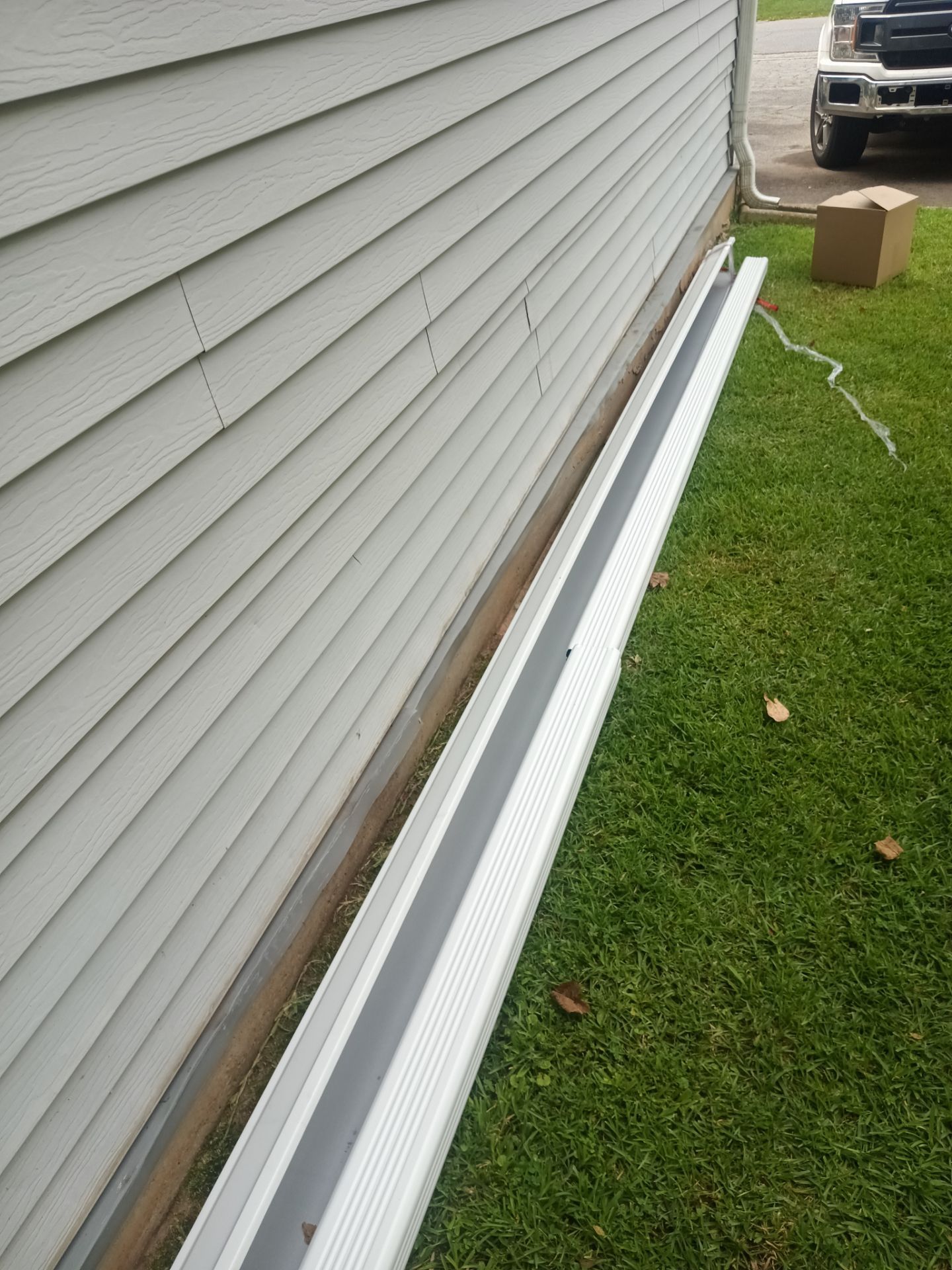 New gutter section laid along the side of a home before it goes up