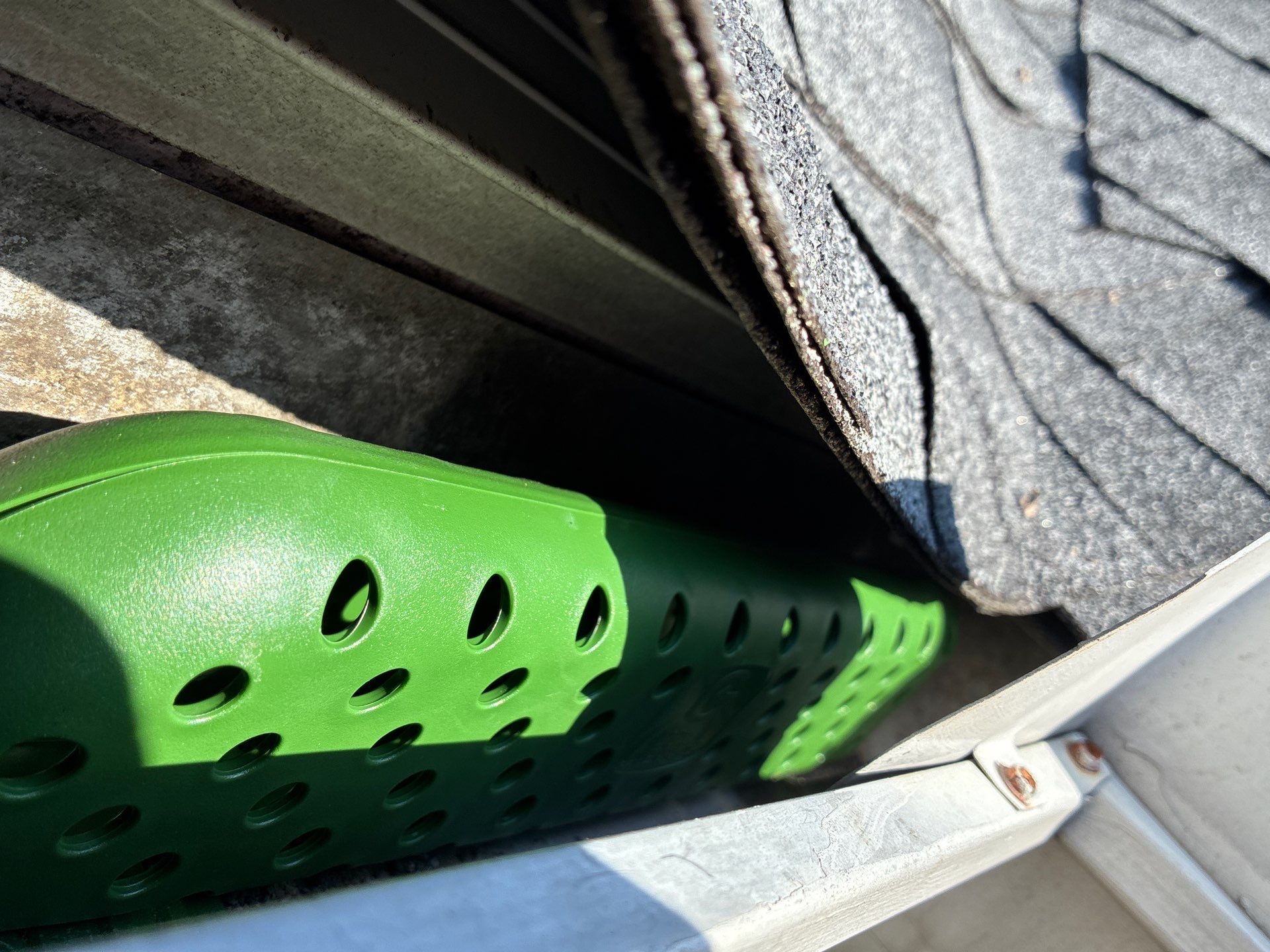 Debris packed inside a gutter channel weeks after cleaning
