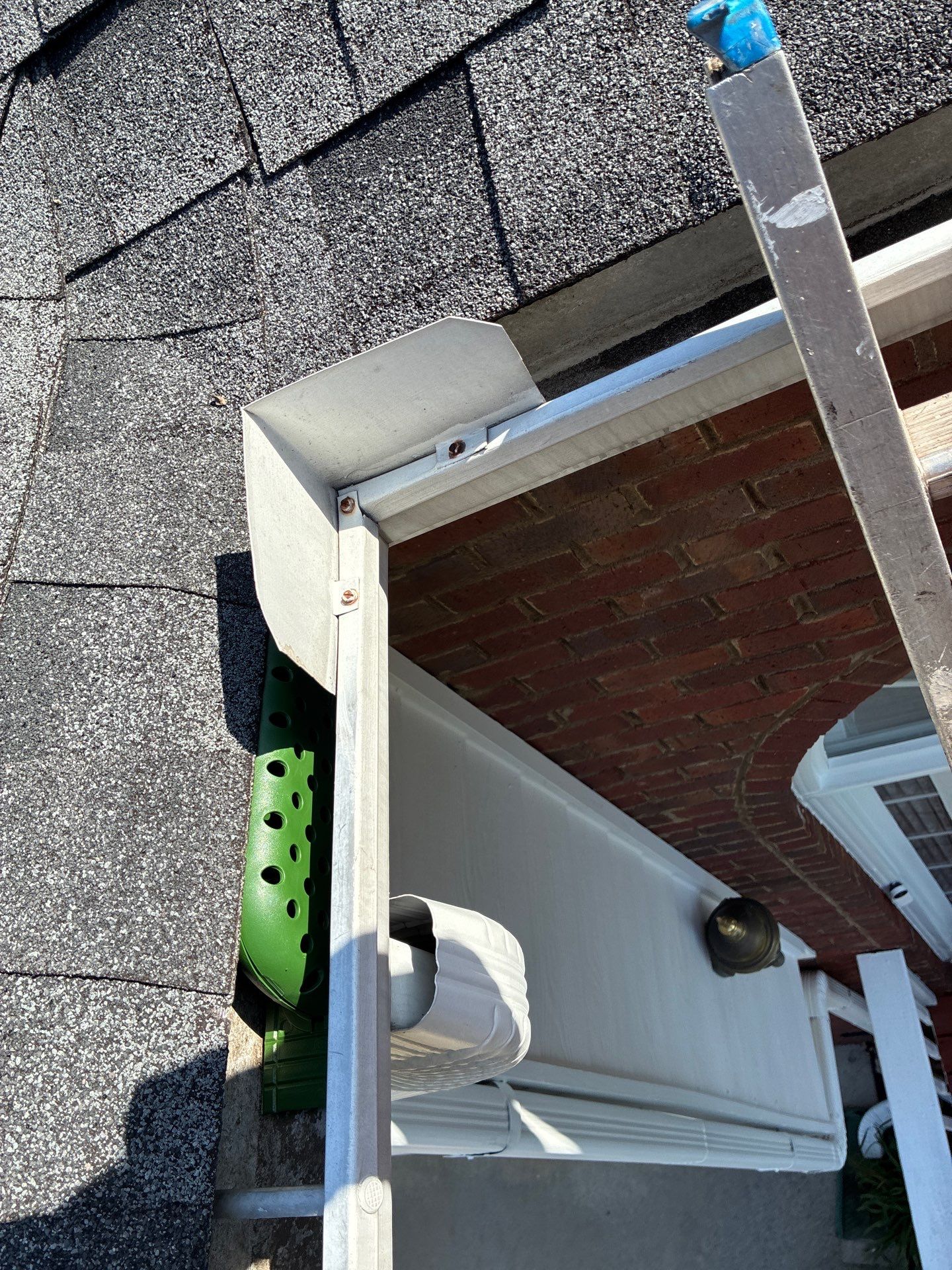 Pine straw resting on top of an installed gutter stick