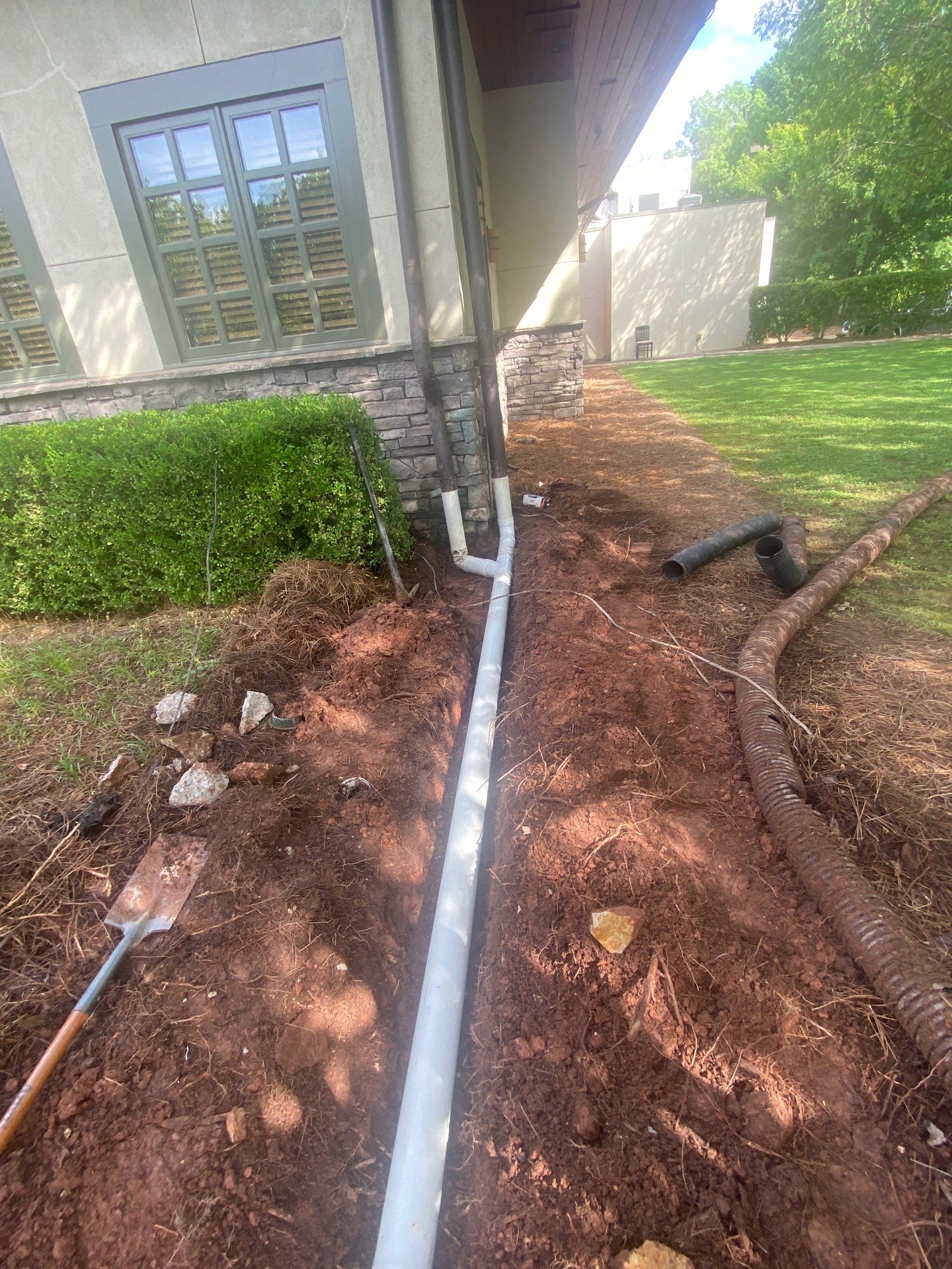 Underground drainage pipe trench running away from a foundation