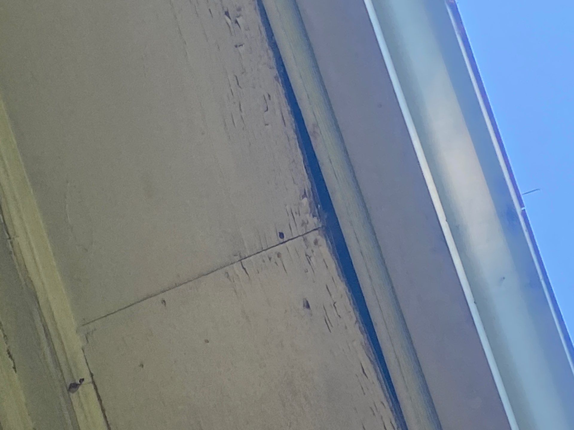 Water staining spreading behind an older wood soffit