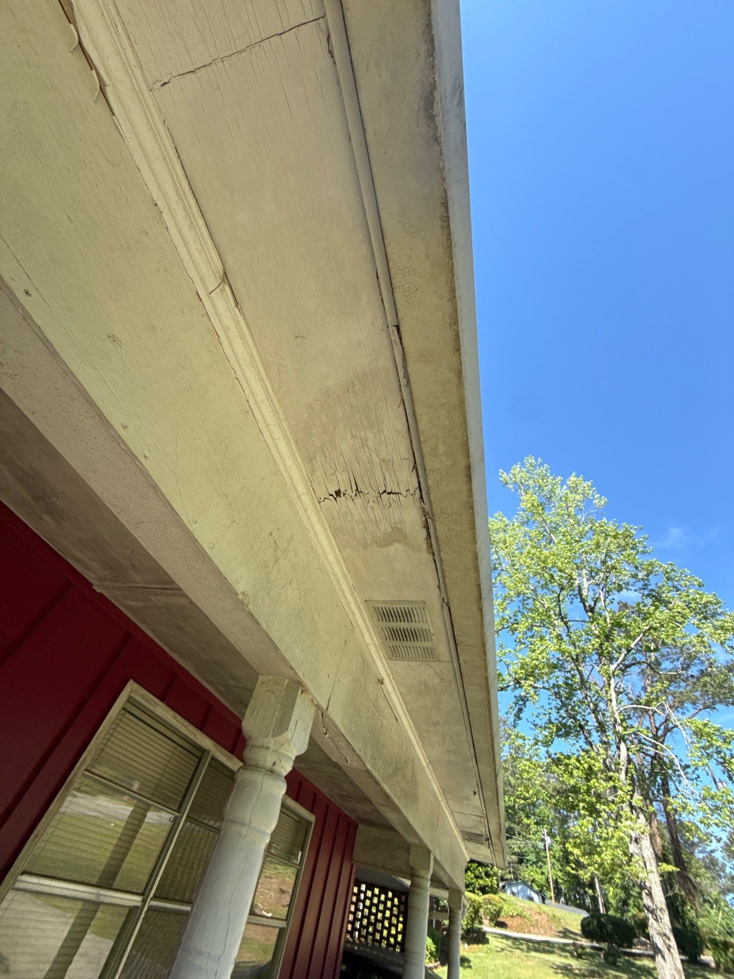 White soffit running along a porch roofline against a blue sky