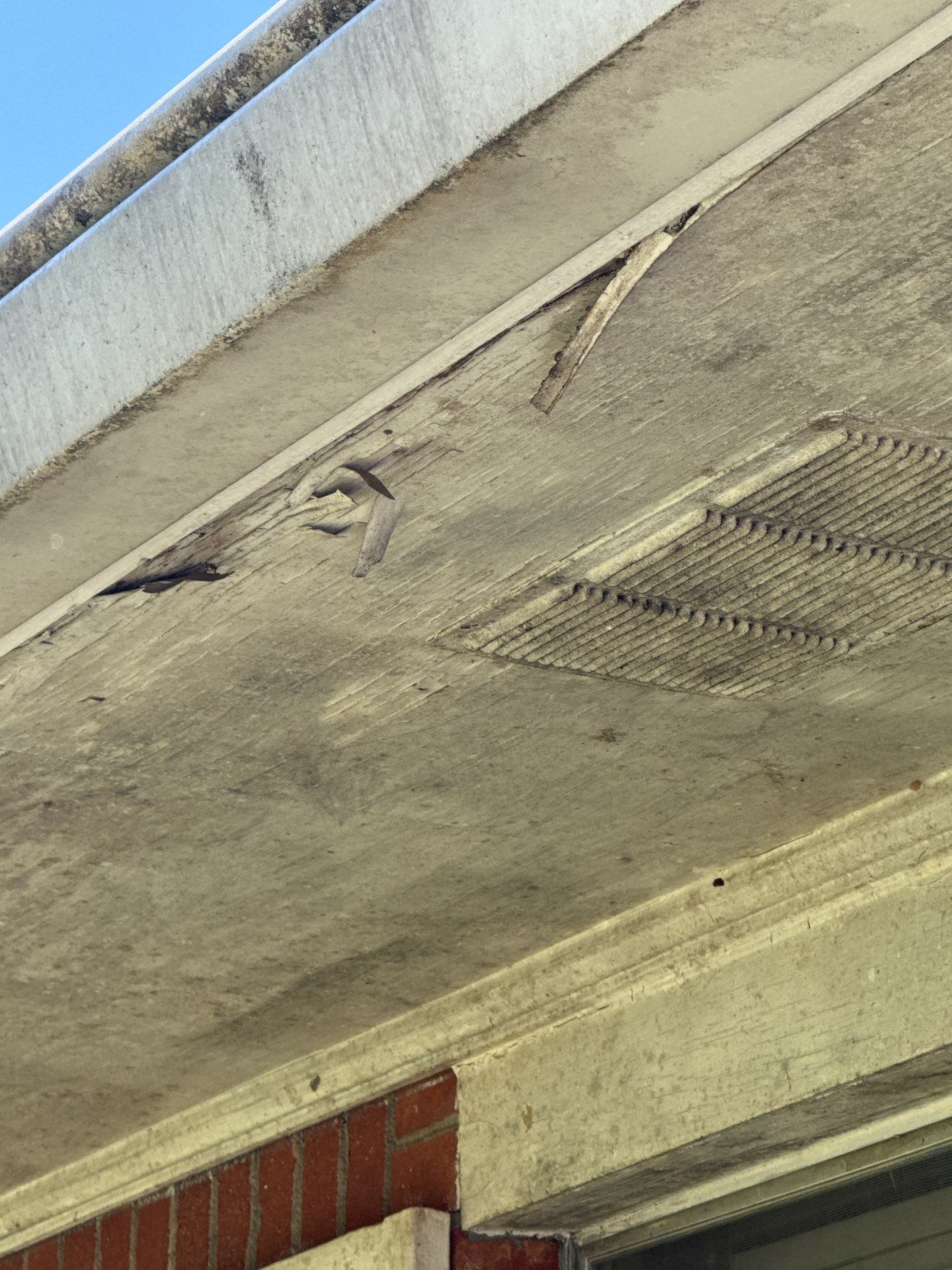 Soffit panel with a visible gap and worn fastening points