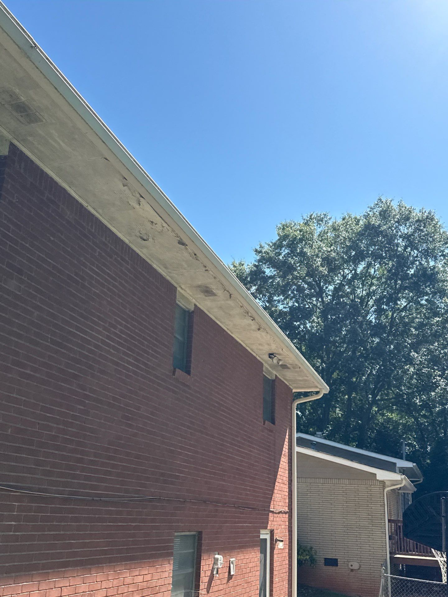 Brick home with soffit and fascia along the roofline under a blue sky
