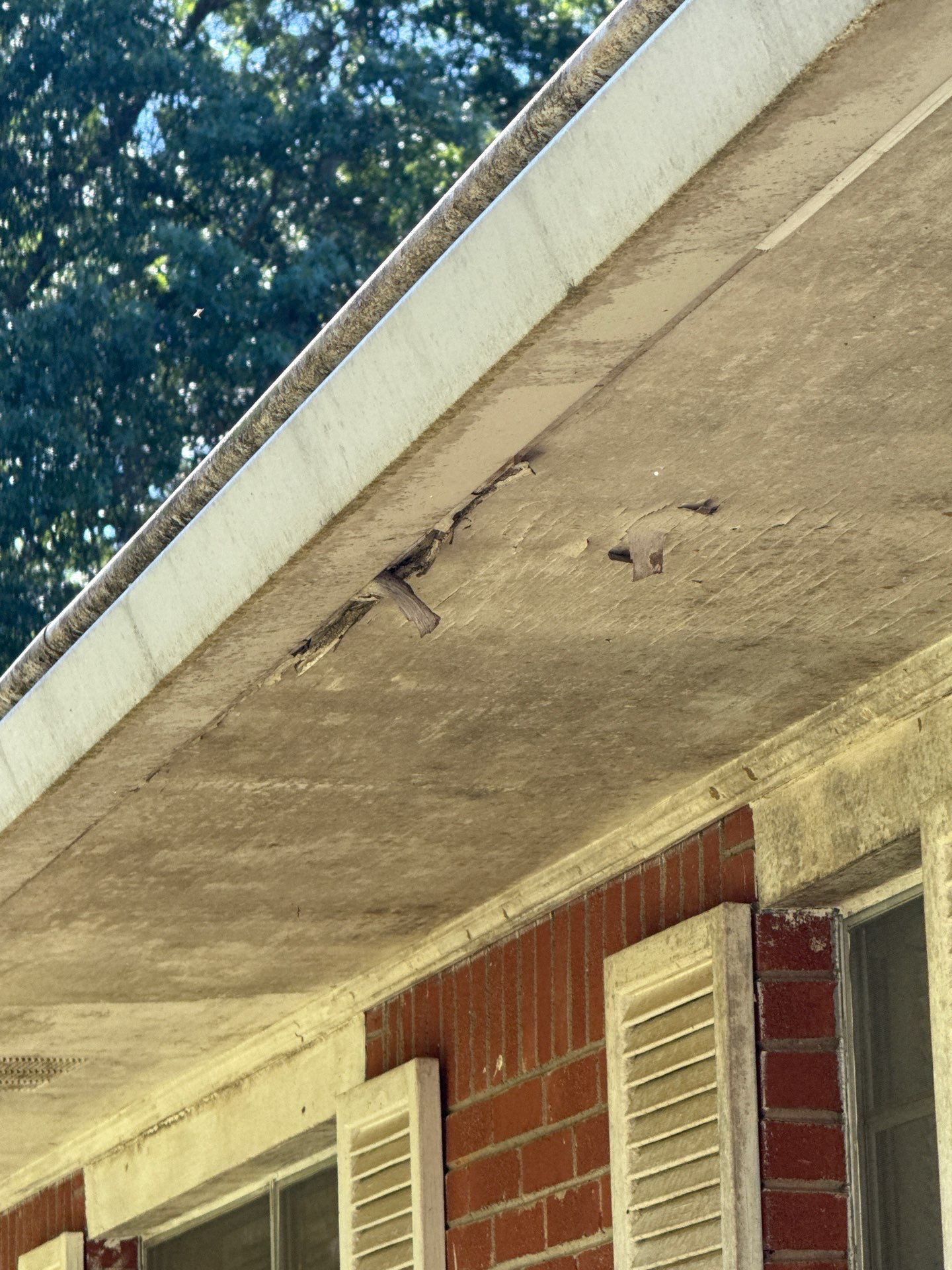 Isolated soffit damage limited to one section near the shutters