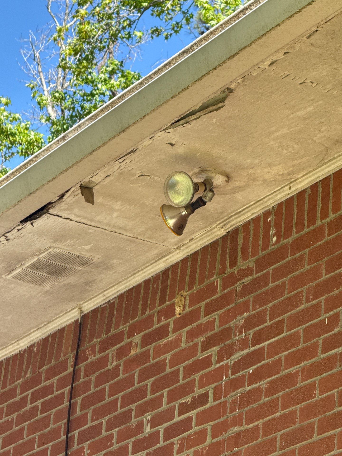 Brick wall and soffit with an exterior light fixture