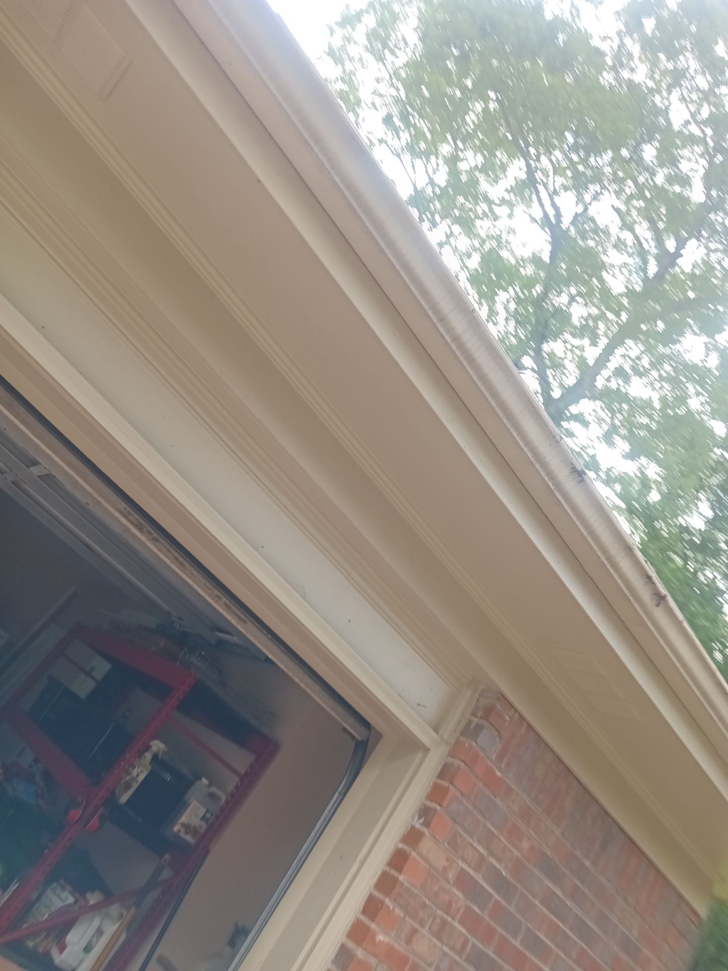 Gutter running above a window on a brick wall
