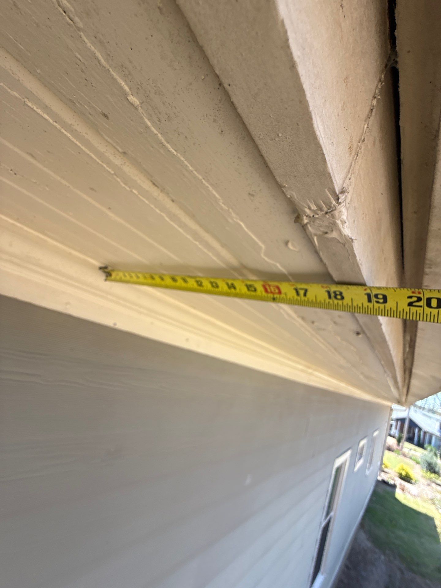 Tape measure held against fascia trim during an inspection