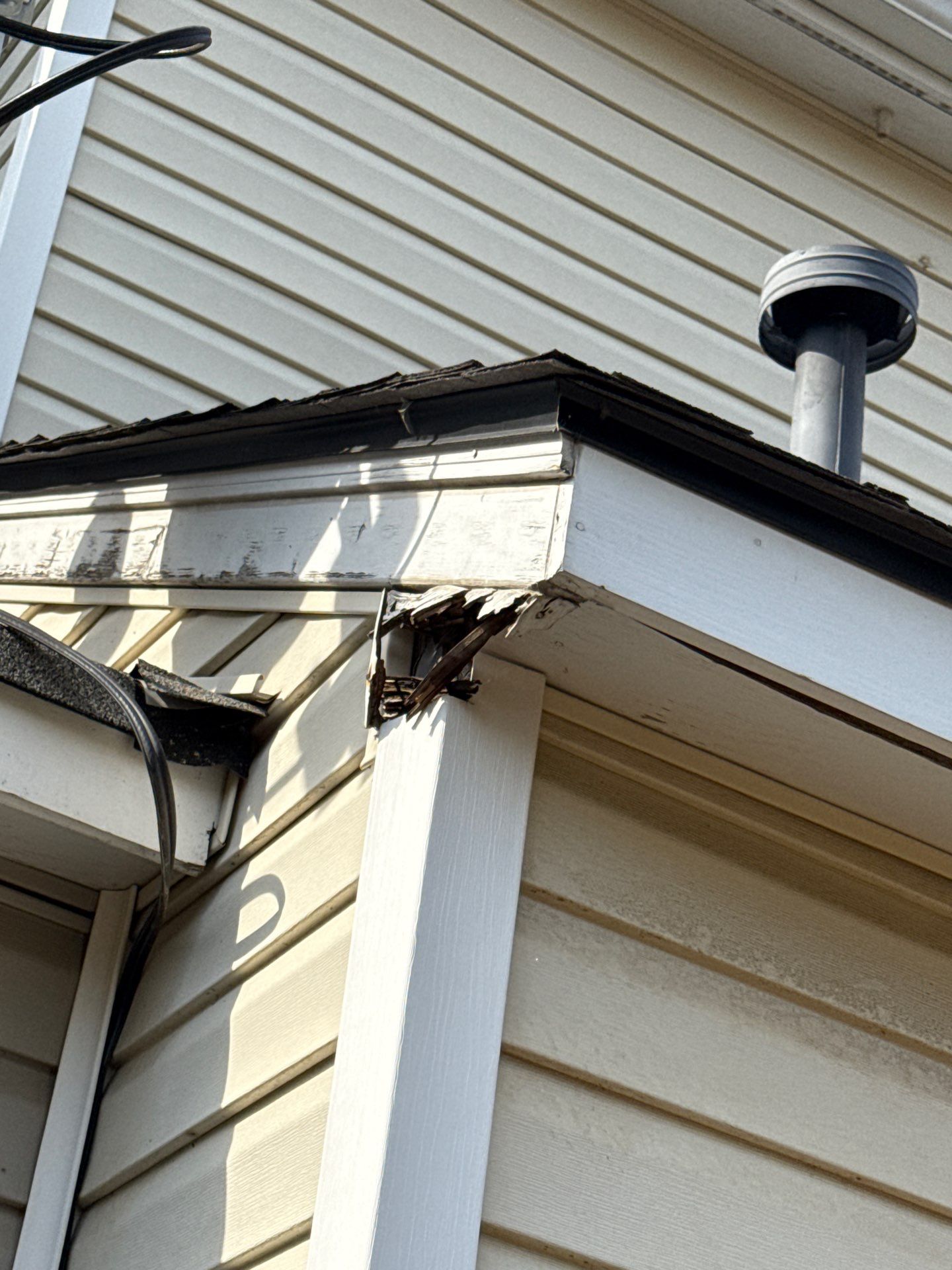 Crack and gap at a fascia corner near a roof vent