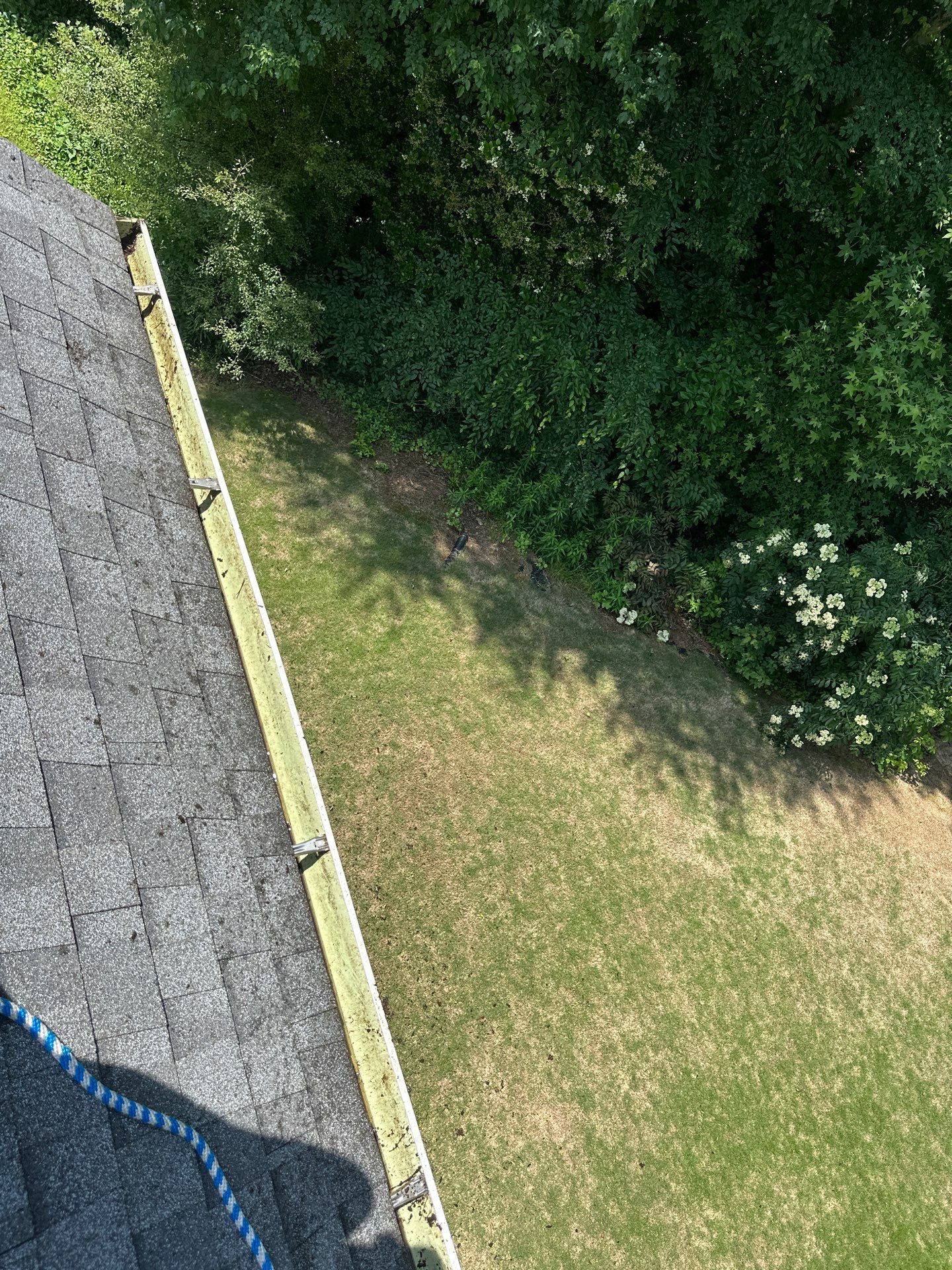 Gutter run along the roof edge above a green lawn