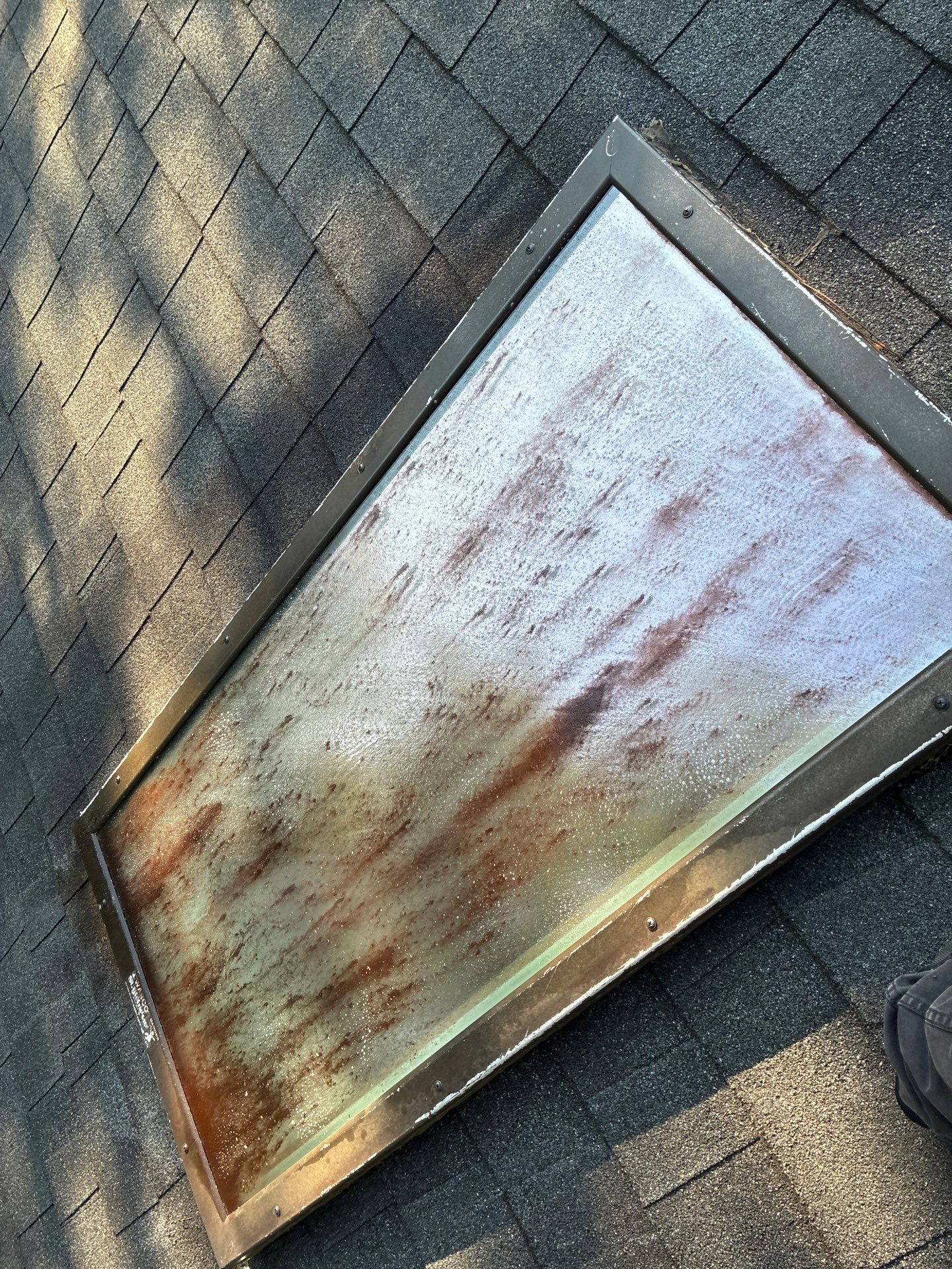 Skylight exterior covered in rust streaks and built-up dirt before a cleaning visit