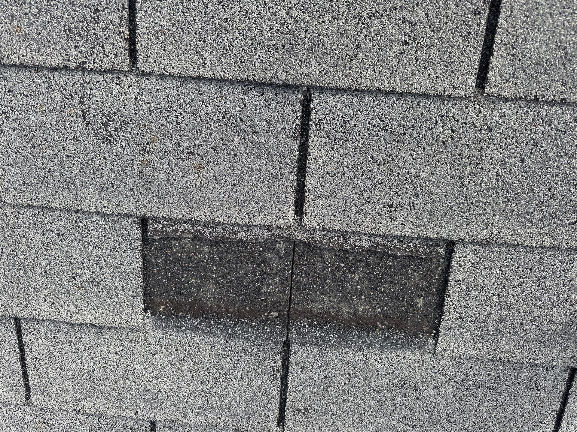 Close-up of a single replaced shingle patched into an existing course