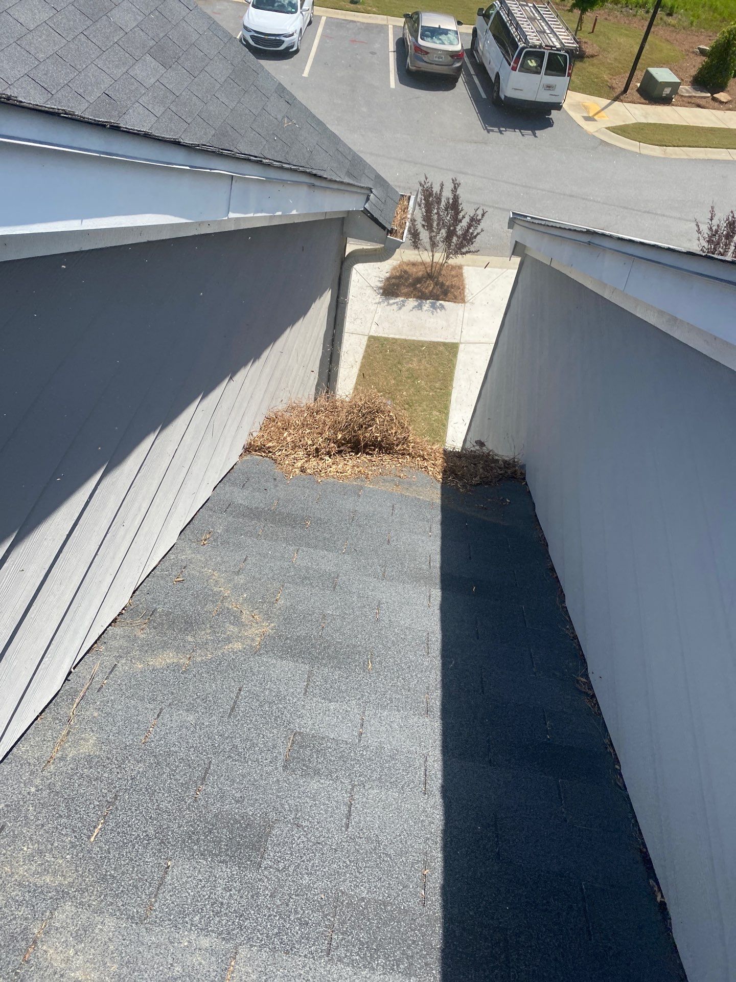 Low-slope roof section and gutter run above a parking area