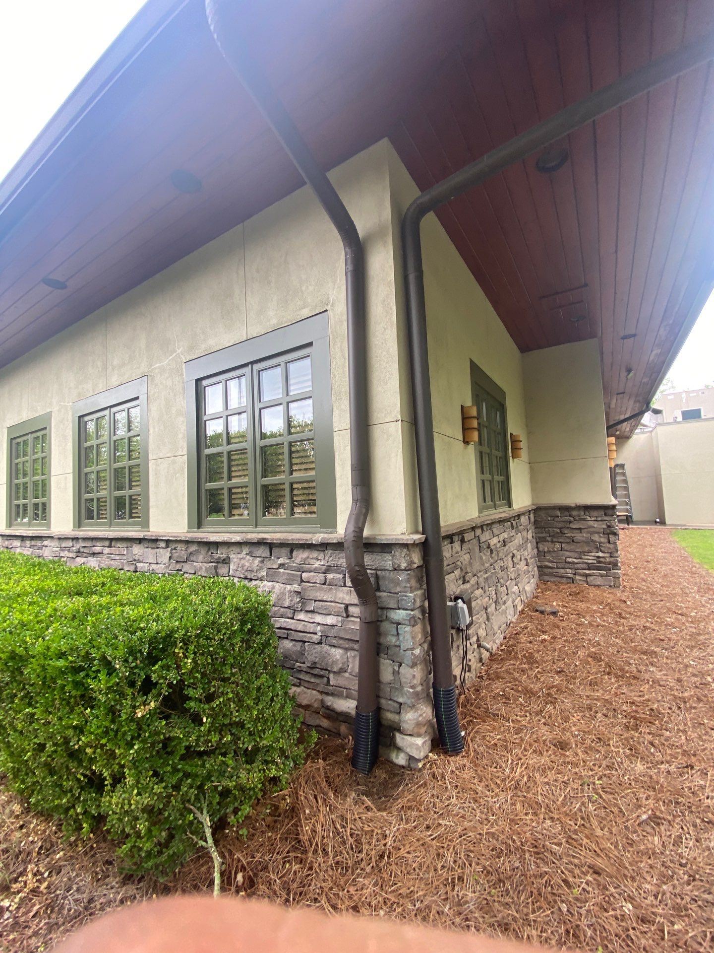 Downspout running down the stone exterior wall of a commercial building