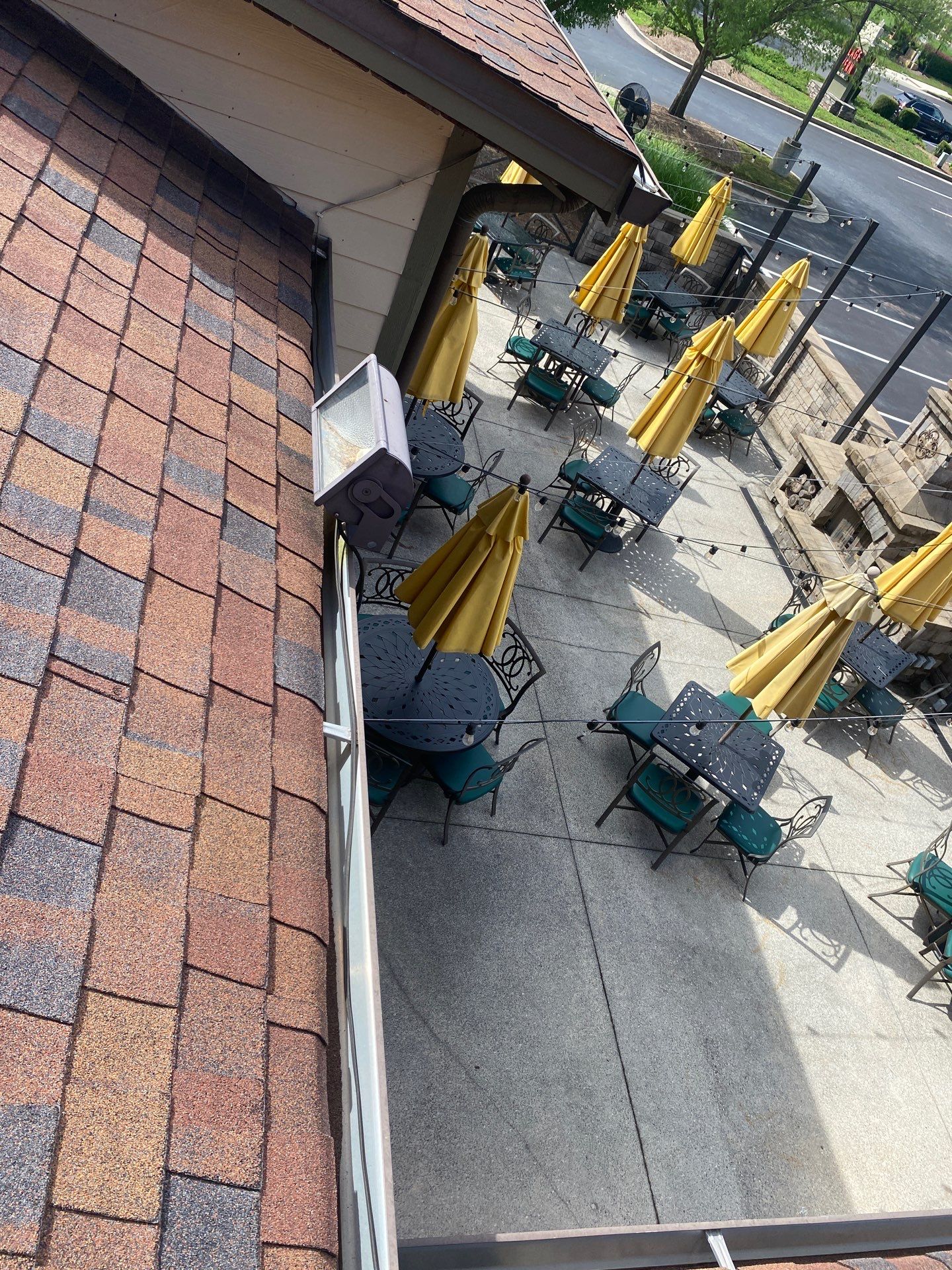 Gutter line above a shared tenant patio area at a multi-unit property
