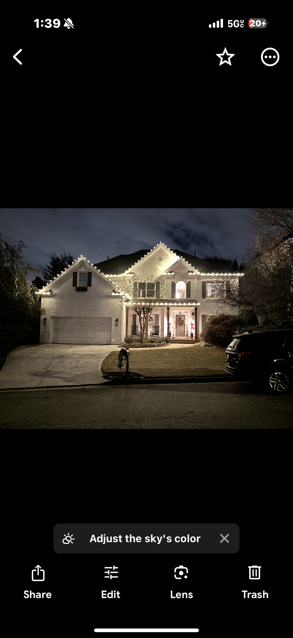 Two-story home lit up at night with lights along every roofline and gable