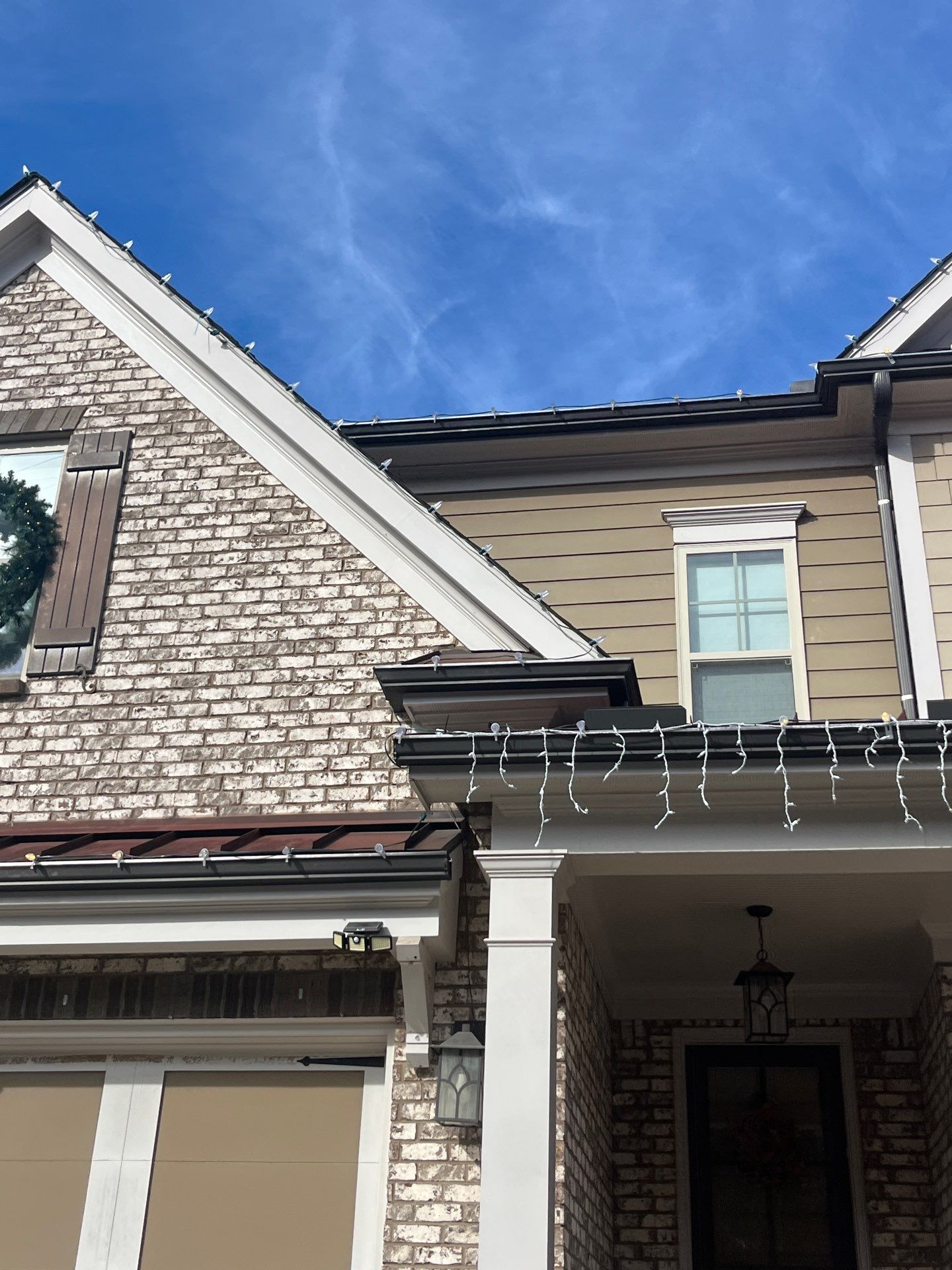 All-weather clips holding a light strand along the gutter edge of a roofline