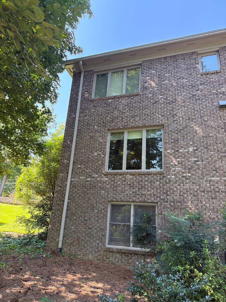Three-story brick home with a downspout running the full height of the corner
