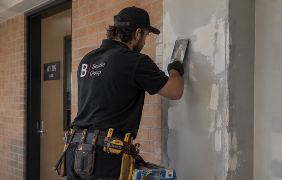 Maintenance worker patching a wall
