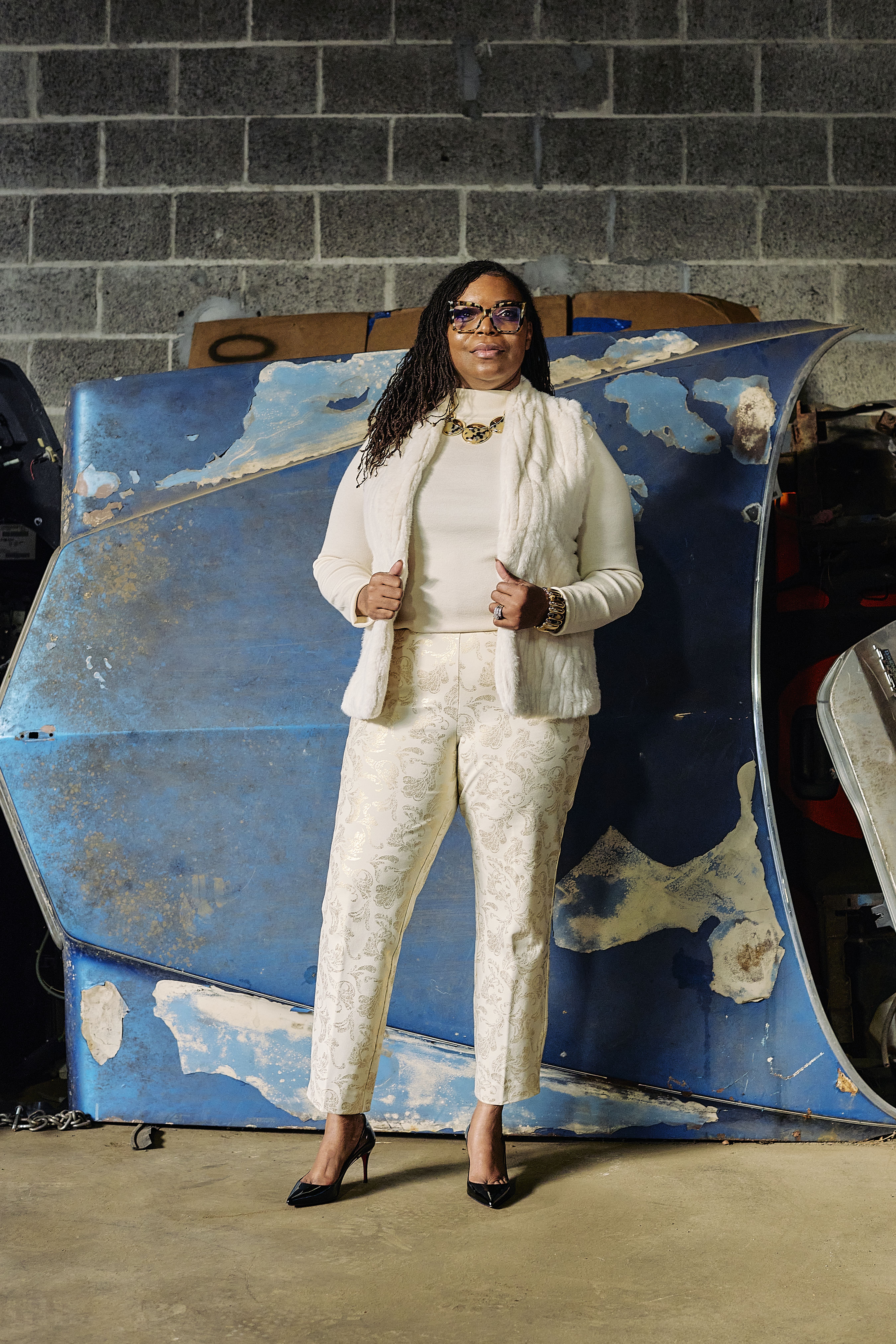 Natasha Broxton standing in front of an automotive part inside her facility