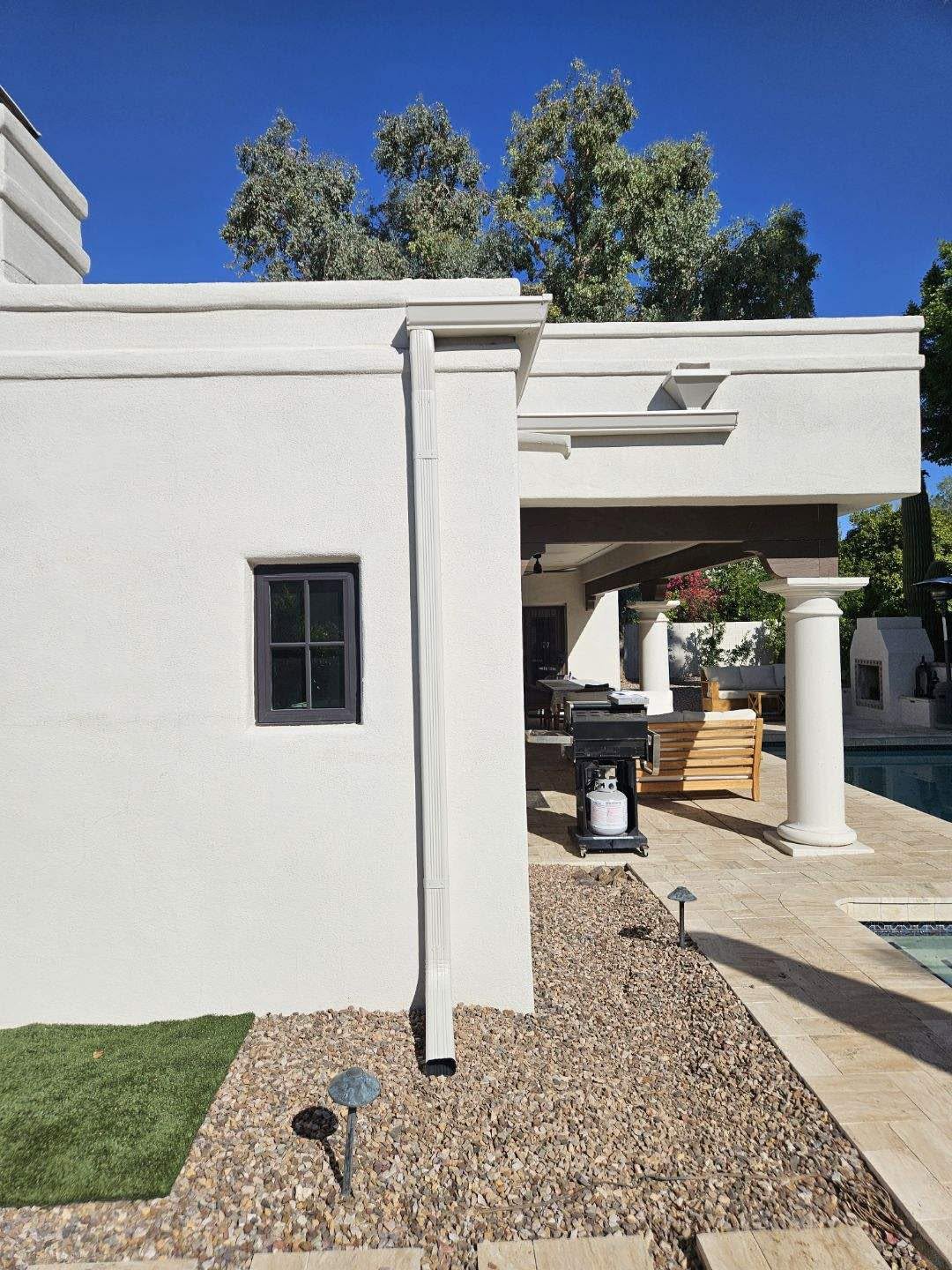 White seamless gutter along the roofline of a columned Phoenix home