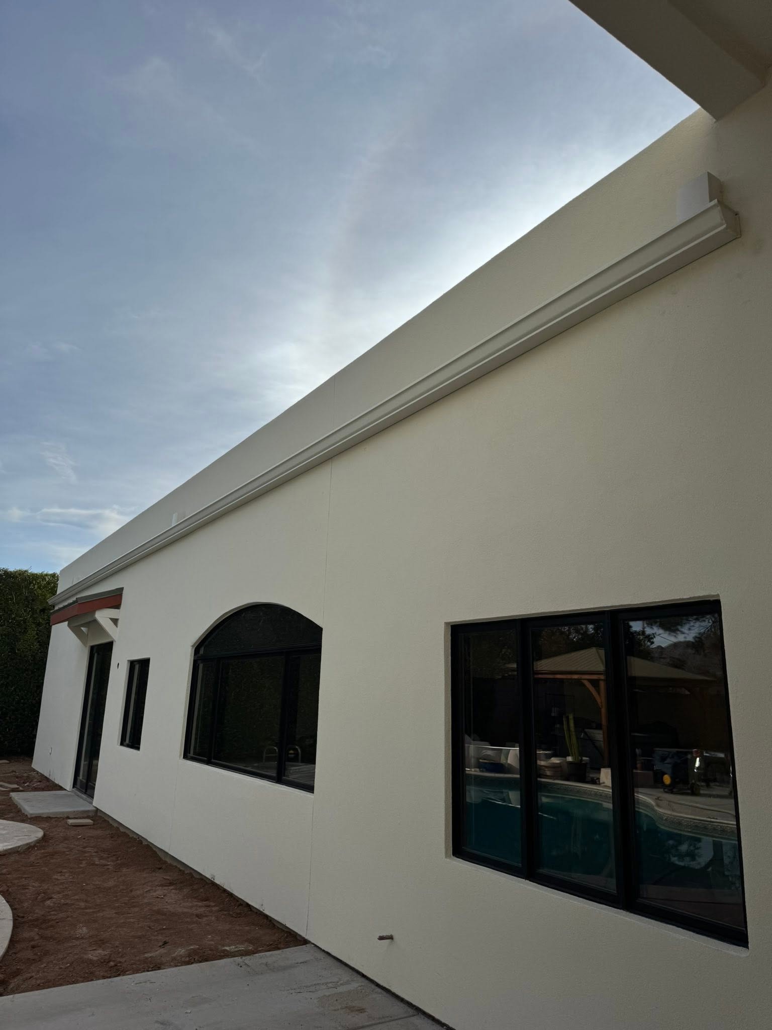 Long seamless gutter run along a Phoenix roofline under a monsoon sky