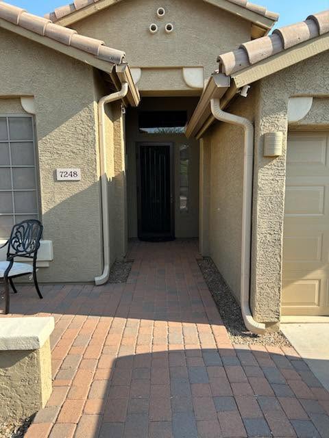Downspout routed down beside a Phoenix home entry