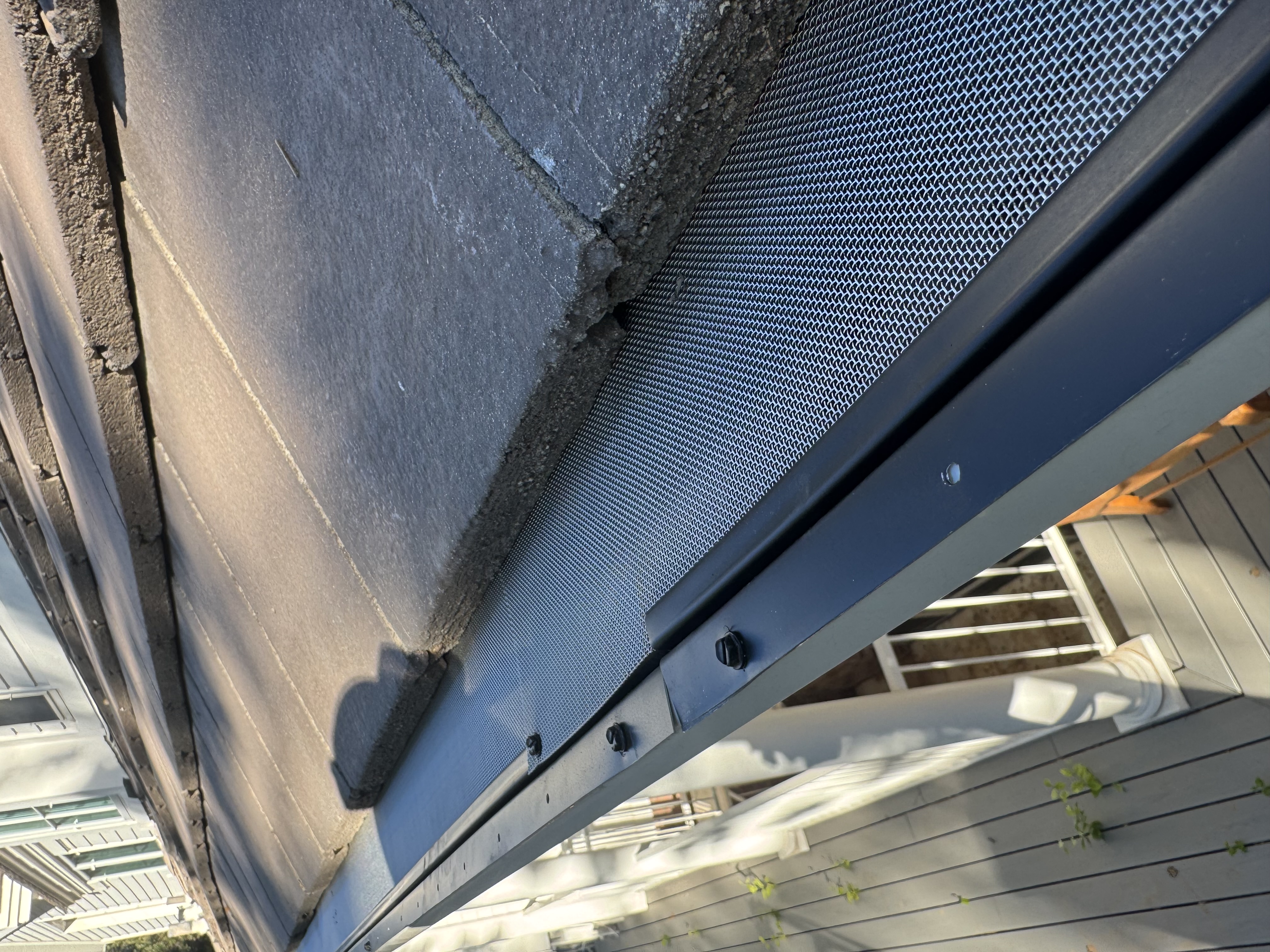 Micro-mesh screen fastened along the front lip of a seamless gutter