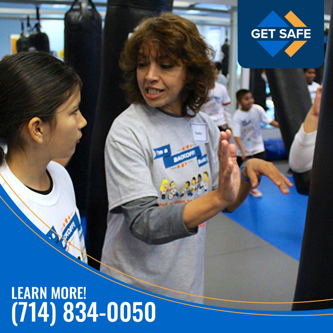 Instructor teaching child self-defense techniques in safety training class