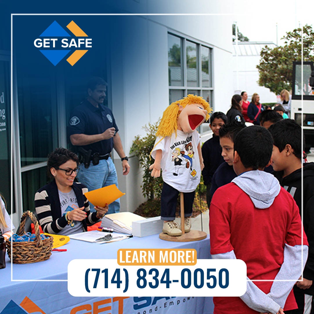 Children participating in community safety education event with instructor and materials