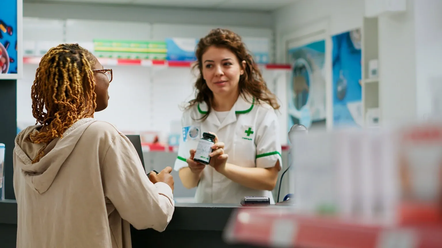 A pharmacist counsels a customer about a prescription