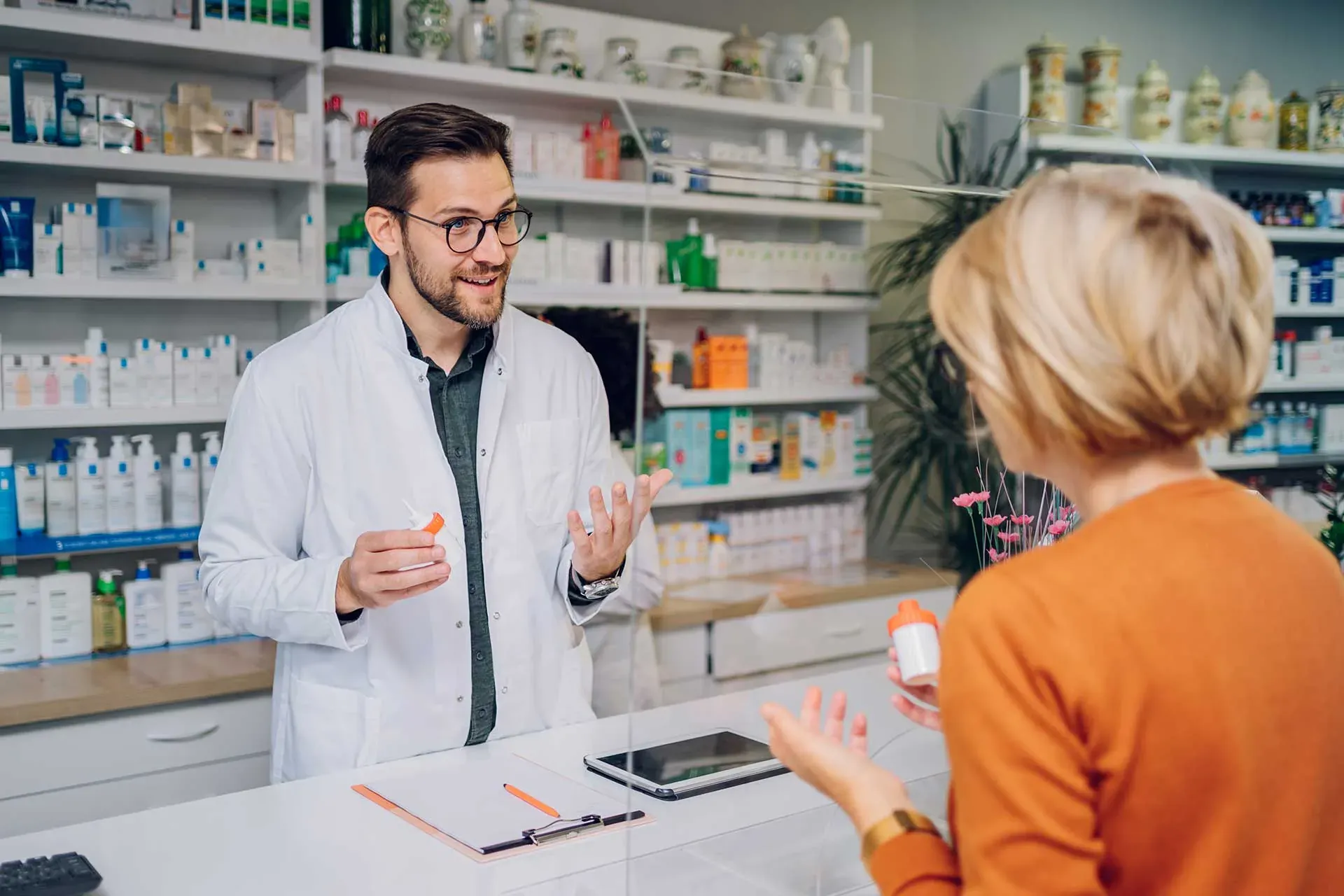 A pharmacist answers a customer's question at the dispensary counter