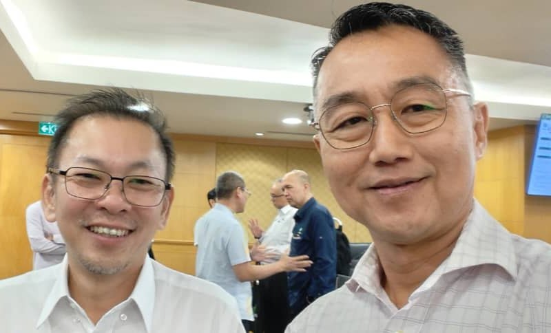Two men photographed together at an indoor event