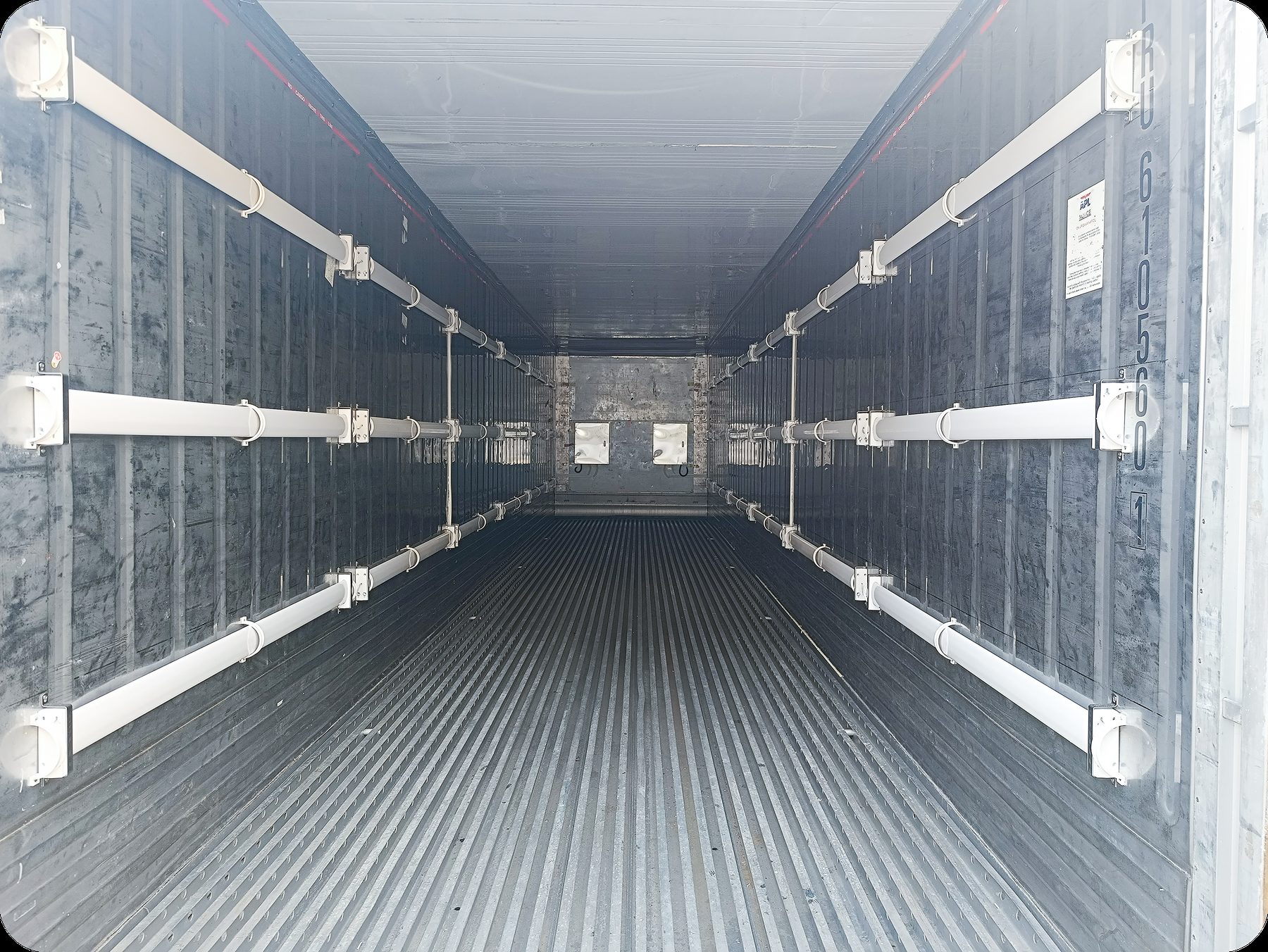 Interior of an empty refrigerated shipping container looking toward the far wall