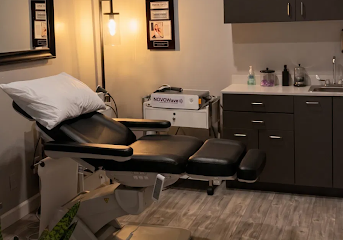 Interior of a medical room with a patient bed, cabinets for supplies, and a desk for medical staff.