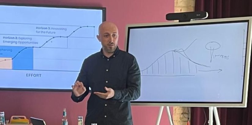 Anees Alomar explaining a curve drawn on a whiteboard at the Mastermind in Karlsruhe.