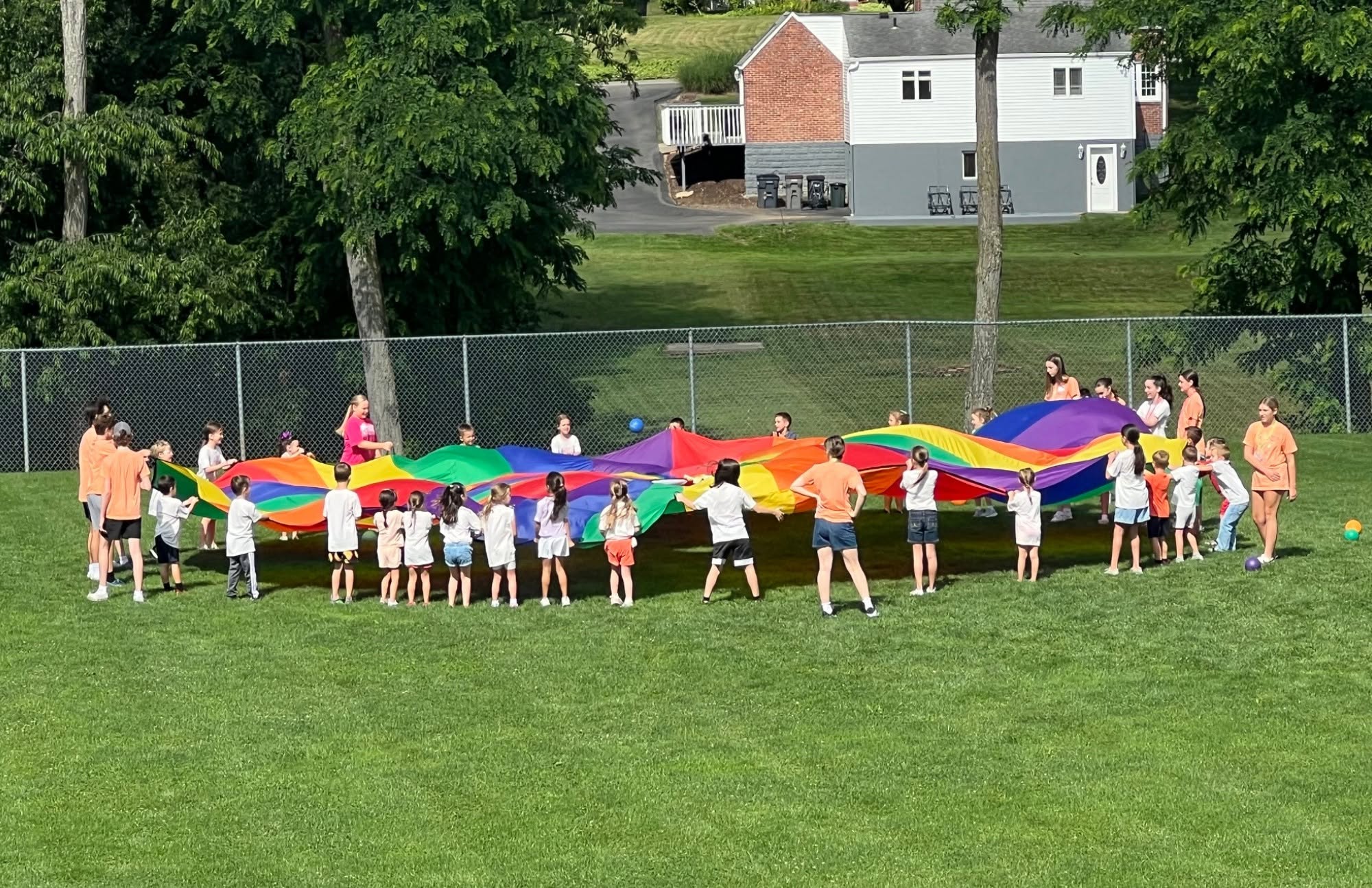 Children and youth ministry leaders playing a parachute game at a St. Catherine Labouré family event
