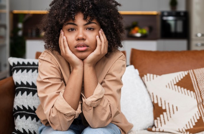 Woman looking stressed, benefiting from hypnosis for anxiety relief and stress reduction therapy.