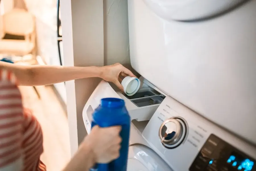 Representative stock photo of a person loading a washing machine