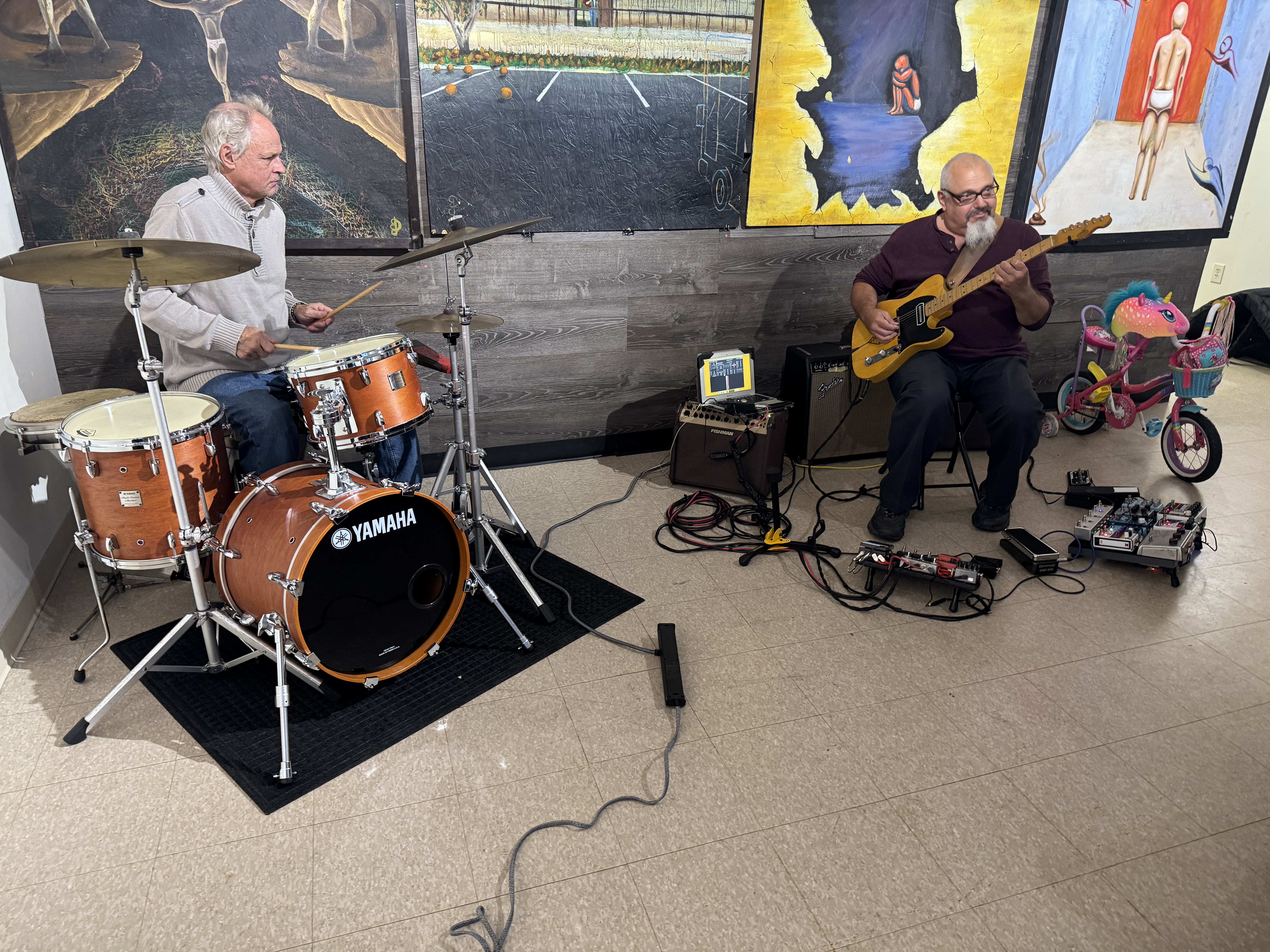 Guitarist preparing for a live performance surrounded by artwork in a gallery