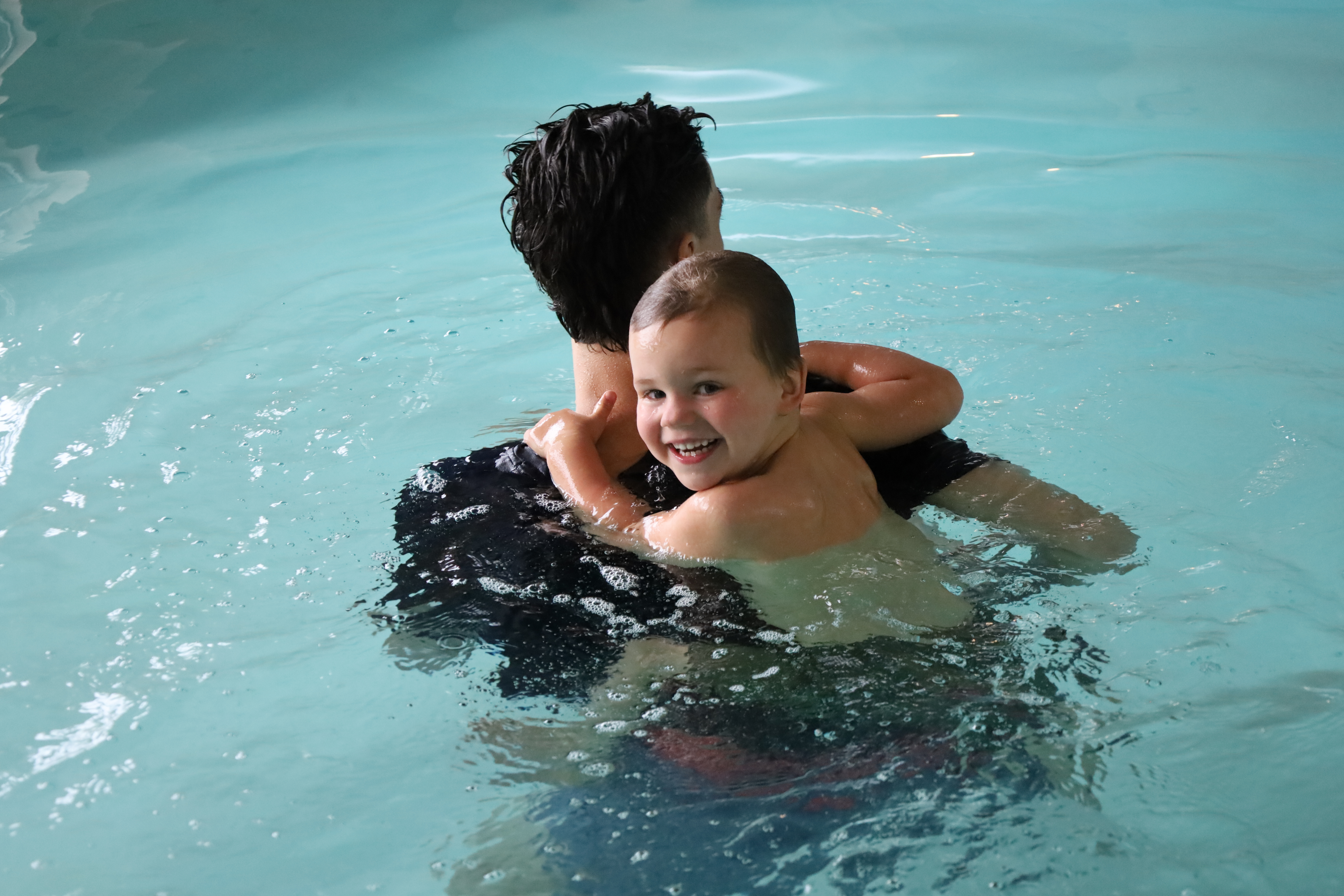 A young swimmer smiling during a lesson at Charlotte Swim Society