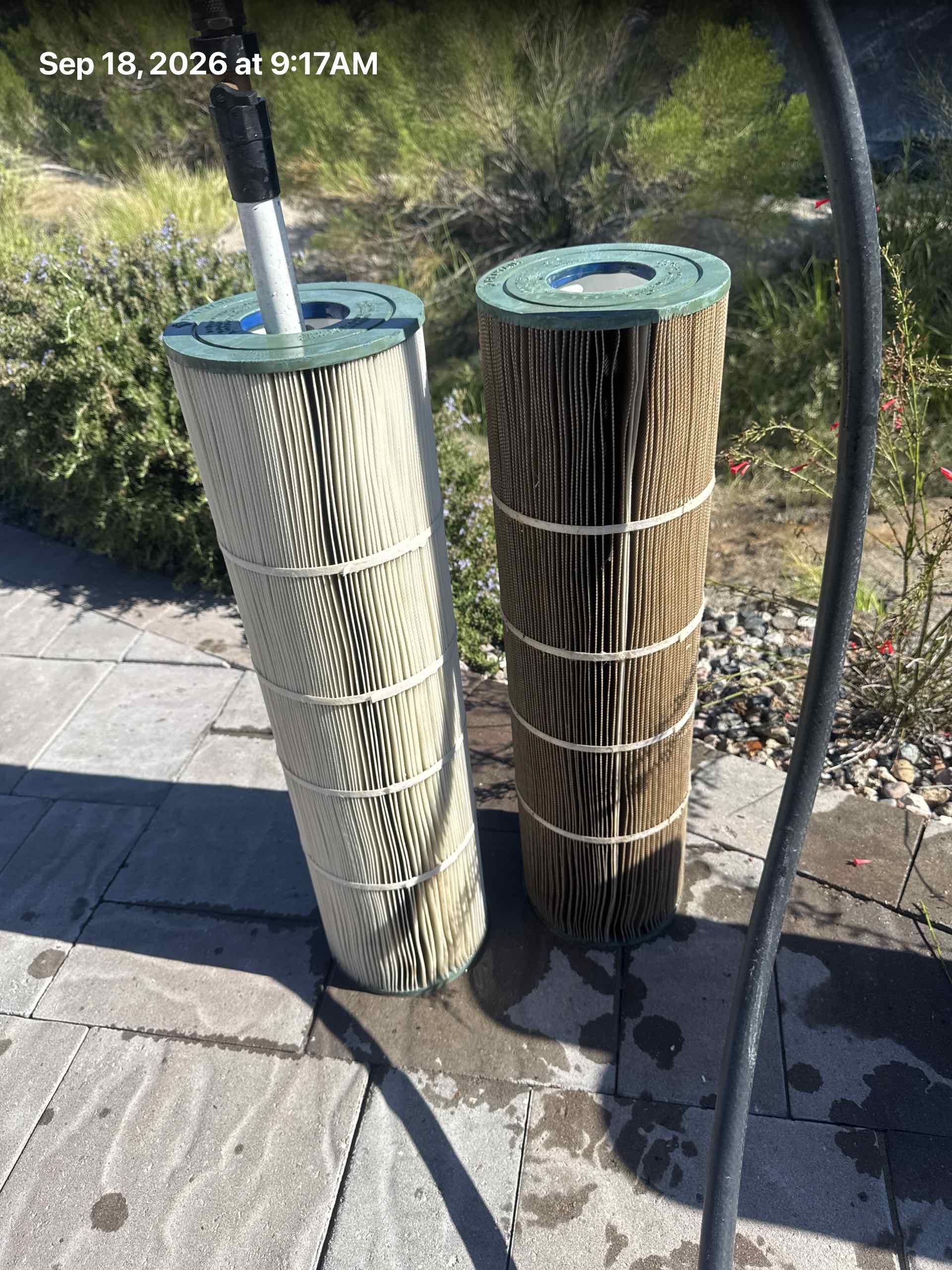 Two pool filter cartridges standing on a patio, one pale and one dark brown and clogged, stamped Sep 18, 2026.