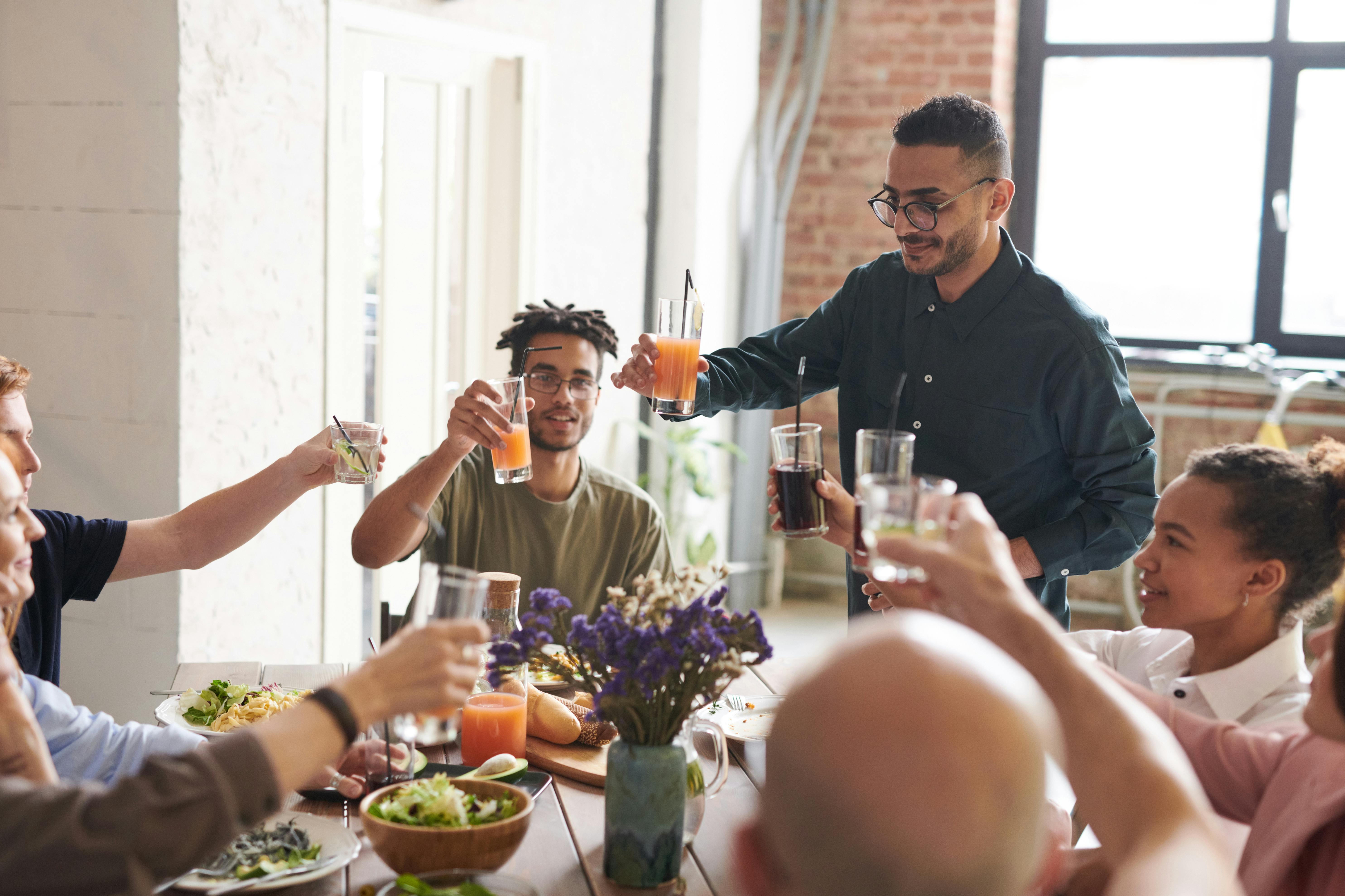 Happy family around a table doing a cheers