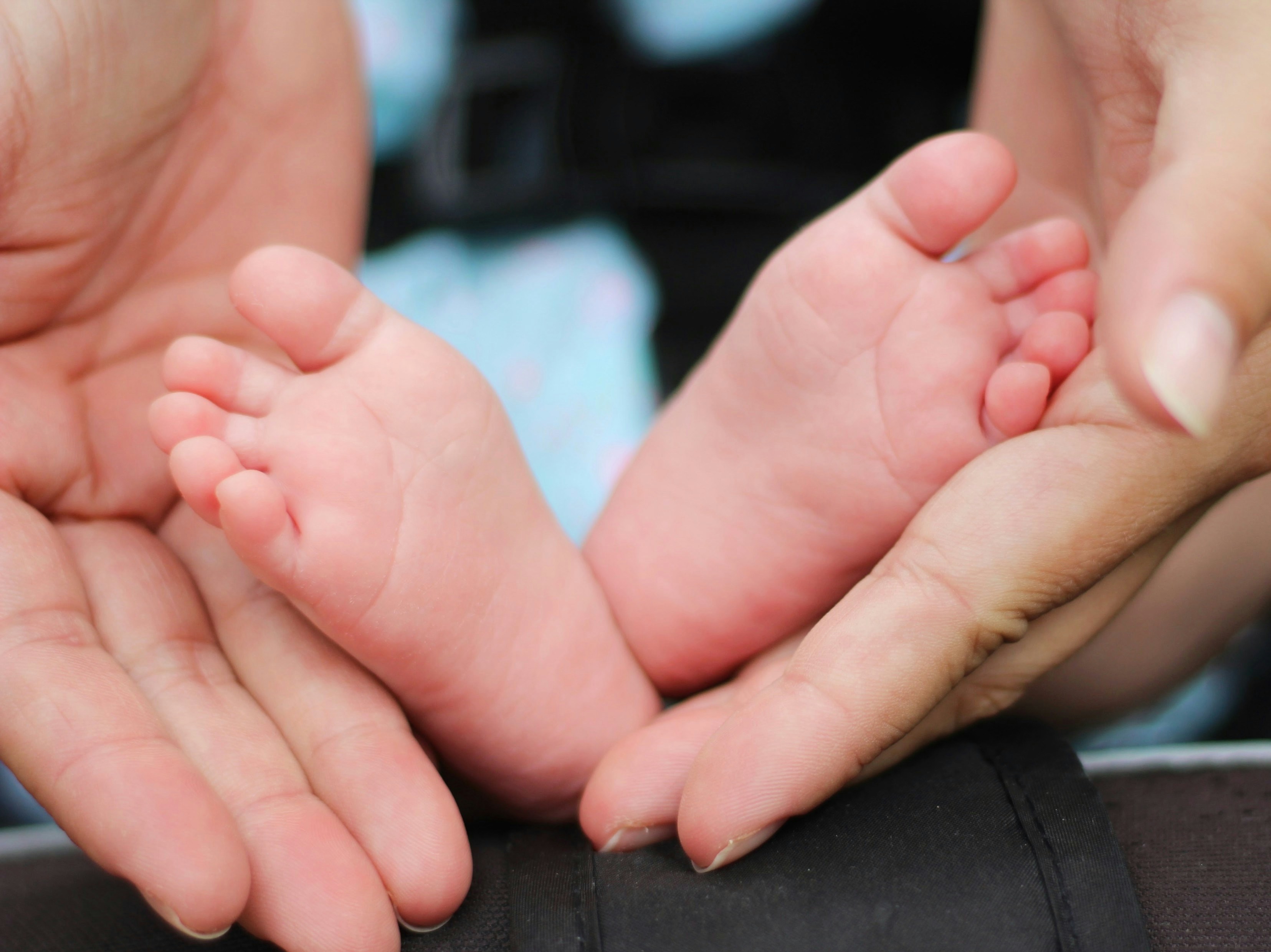 Adult hands cradling baby feet