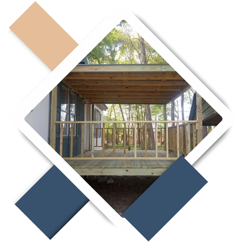 Covered wooden porch with railing attached to a house in the woods