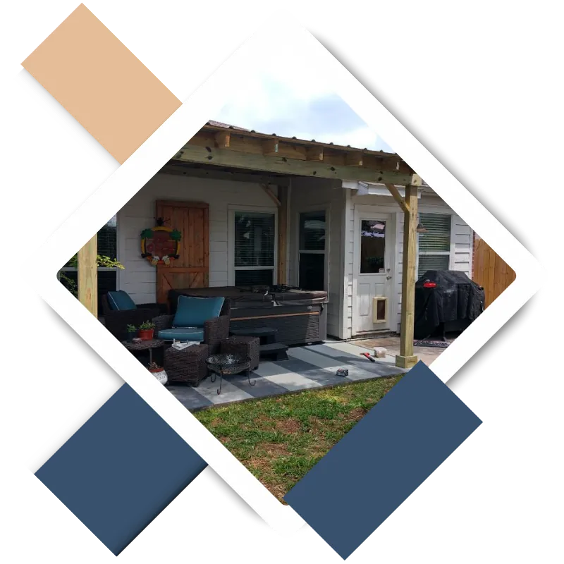Covered patio with seating set, hot tub, and grill beside white house