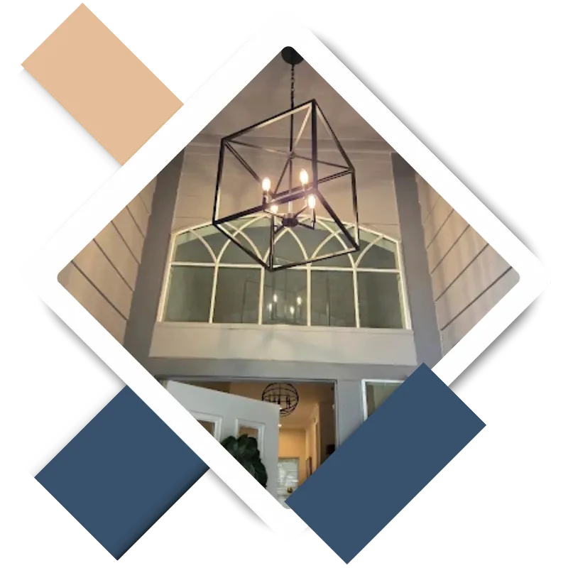 Modern chandelier hanging in a bright entryway with large windows, showcasing interior design suitable for home painting services in Kingwood, TX.