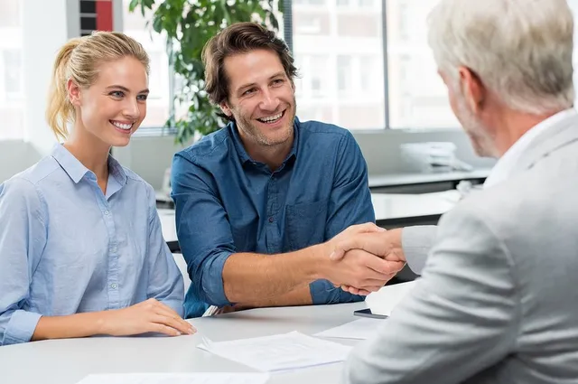 Couple and a man handshaking